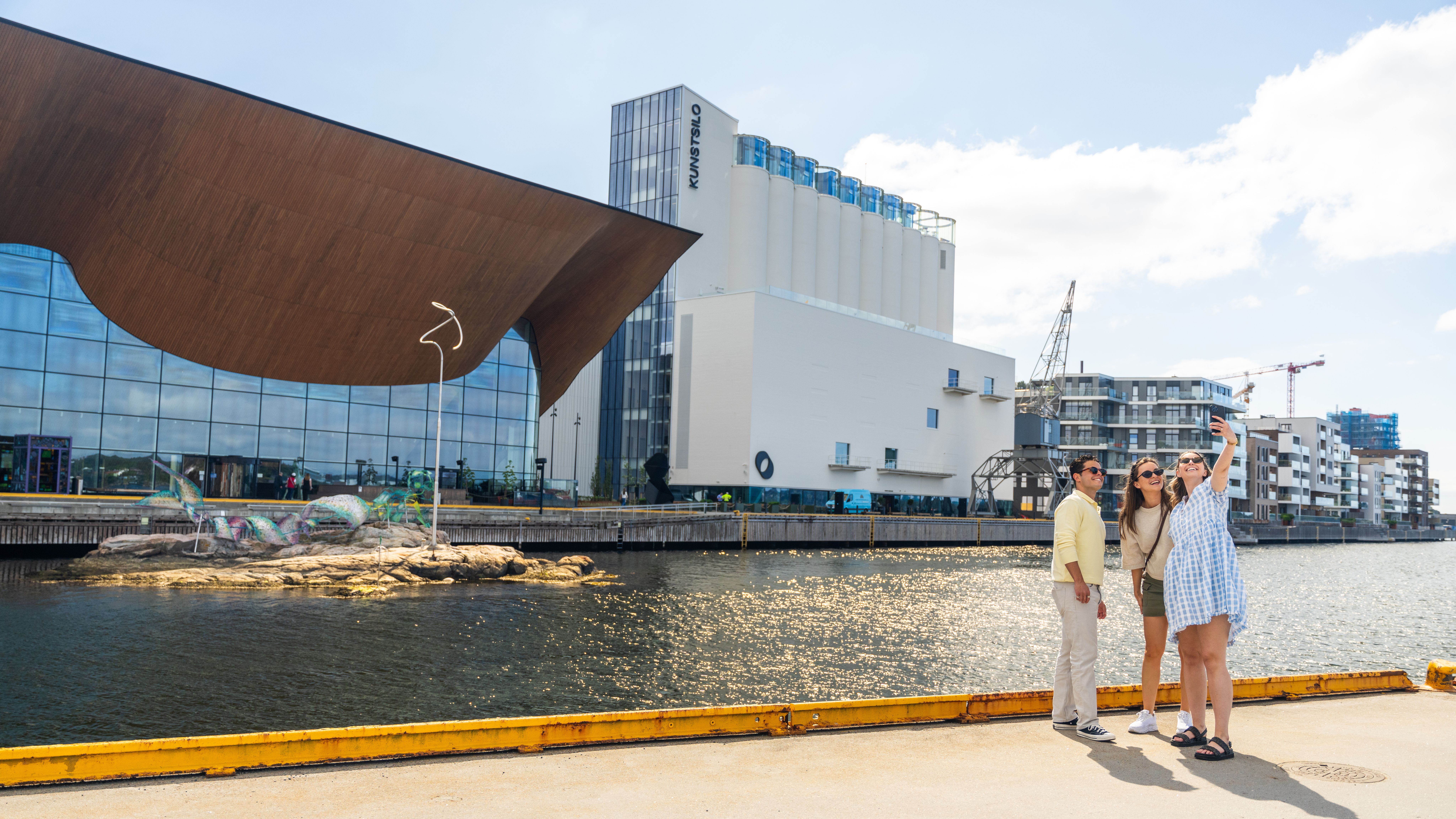 Three people taking a selfie in front of Kilden and Kunstsilo in Kristiansand