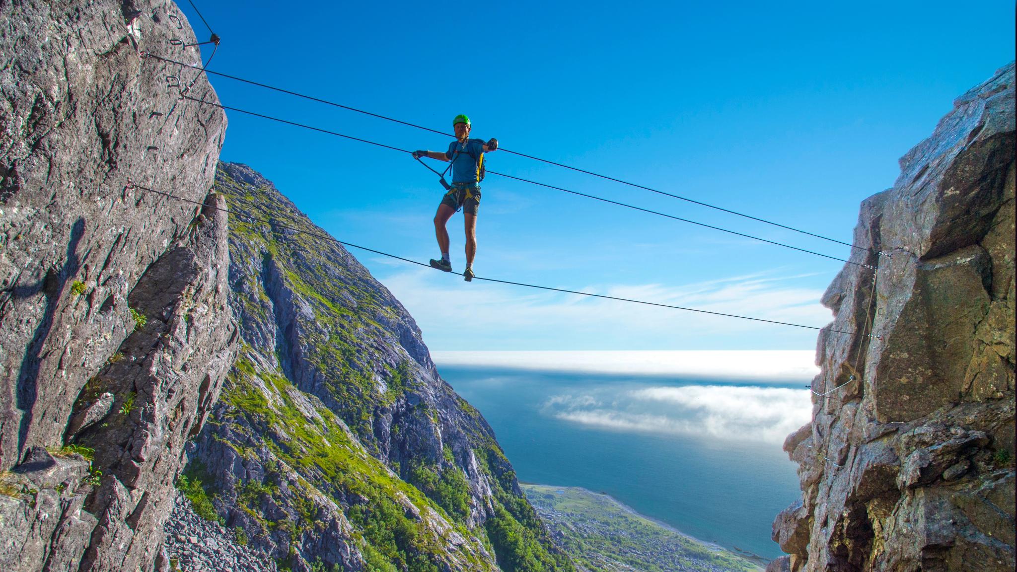 Man climbing the Ravnfloget Via Ferrata in Vega
