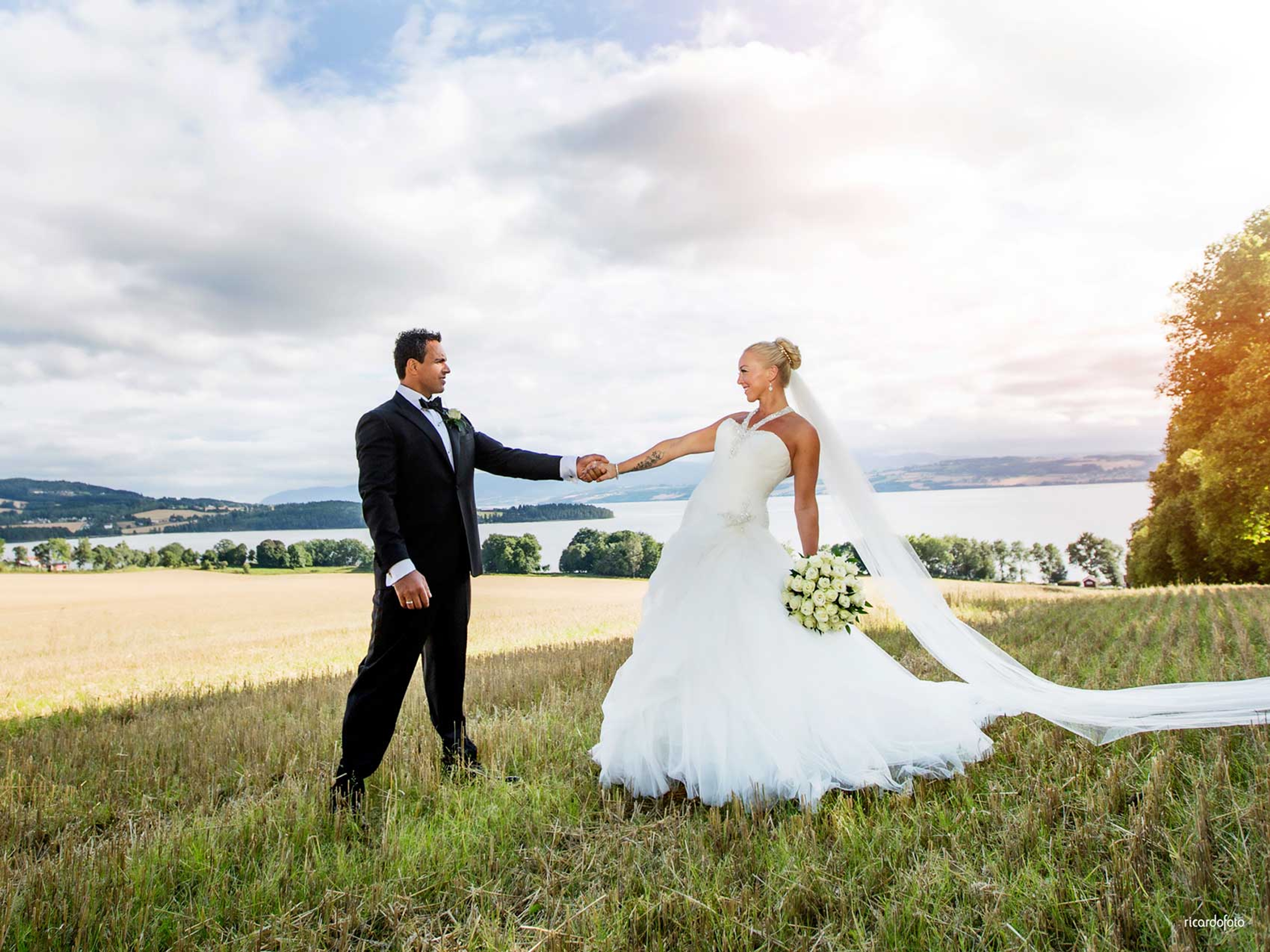A wedding couple holding hands at the fields by Hoel farm in Eastern Norway