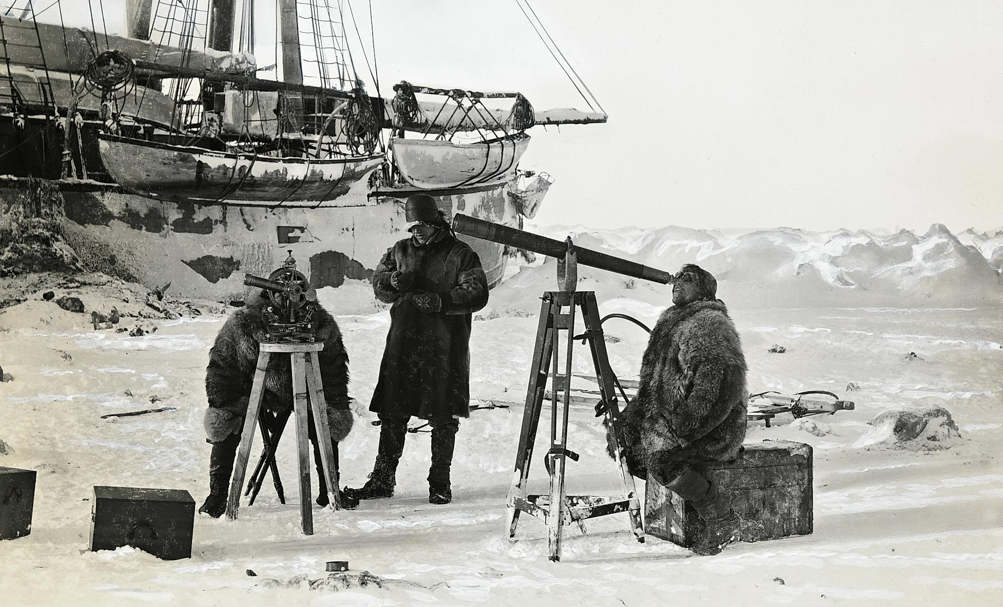 Fridtjof Nansen observing the solar eclipse through a telescope with two of his crew members