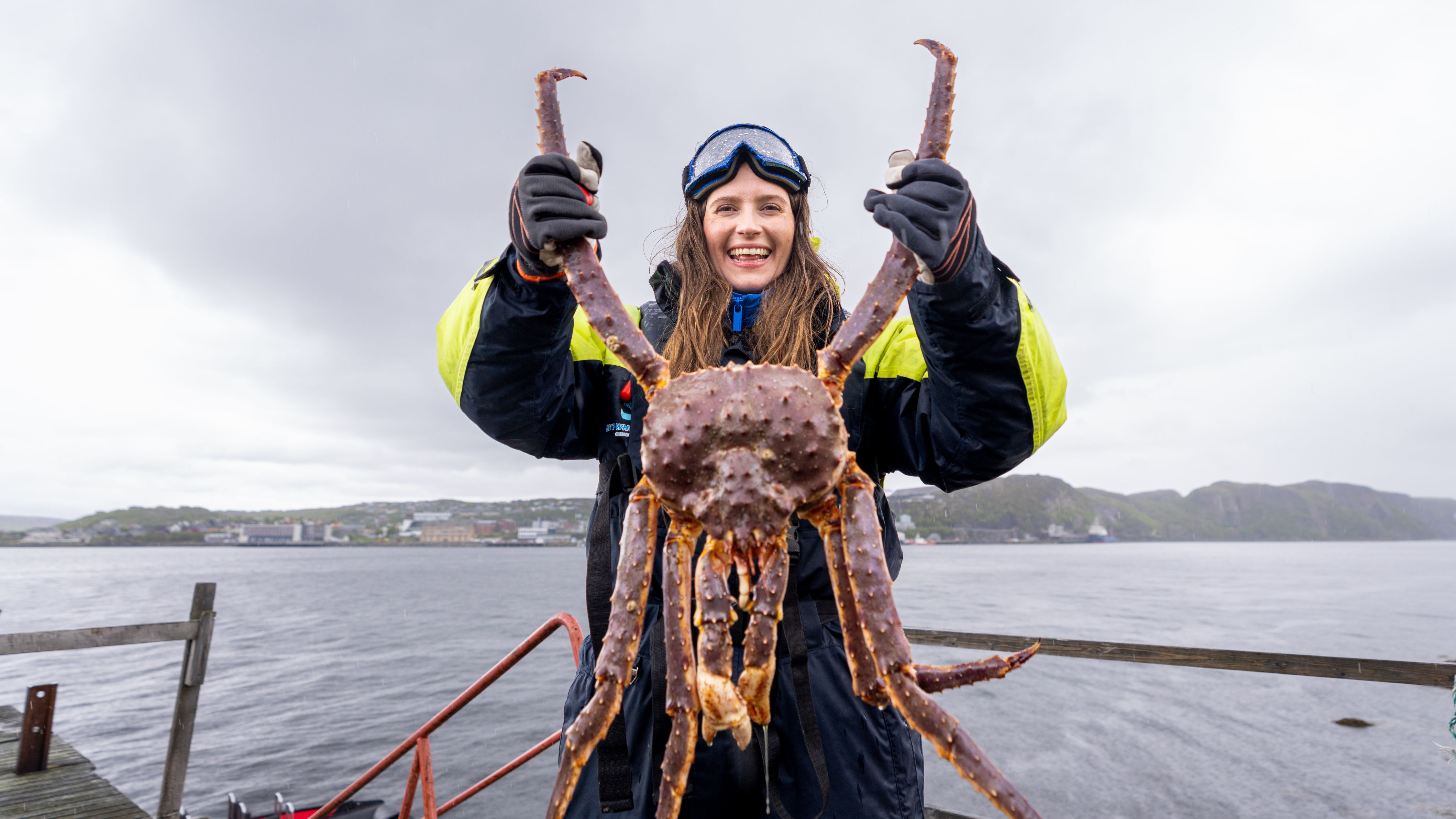 A woman holding a king crab on a king crab safari outside of Kirkenes, Northern Norway
