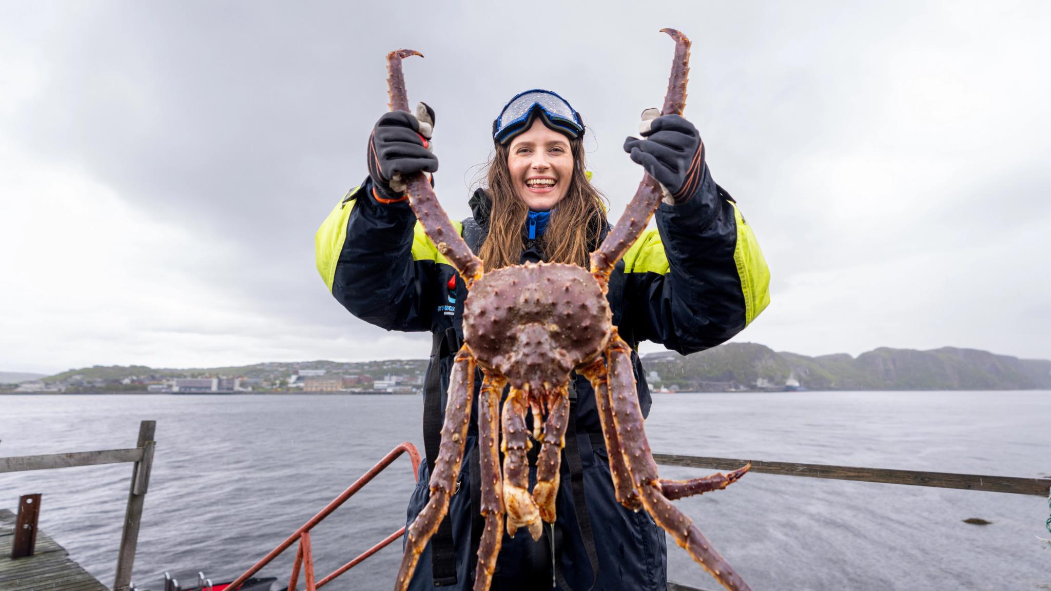 A woman holding a king crab on a king crab safari outside of Kirkenes, Northern Norway