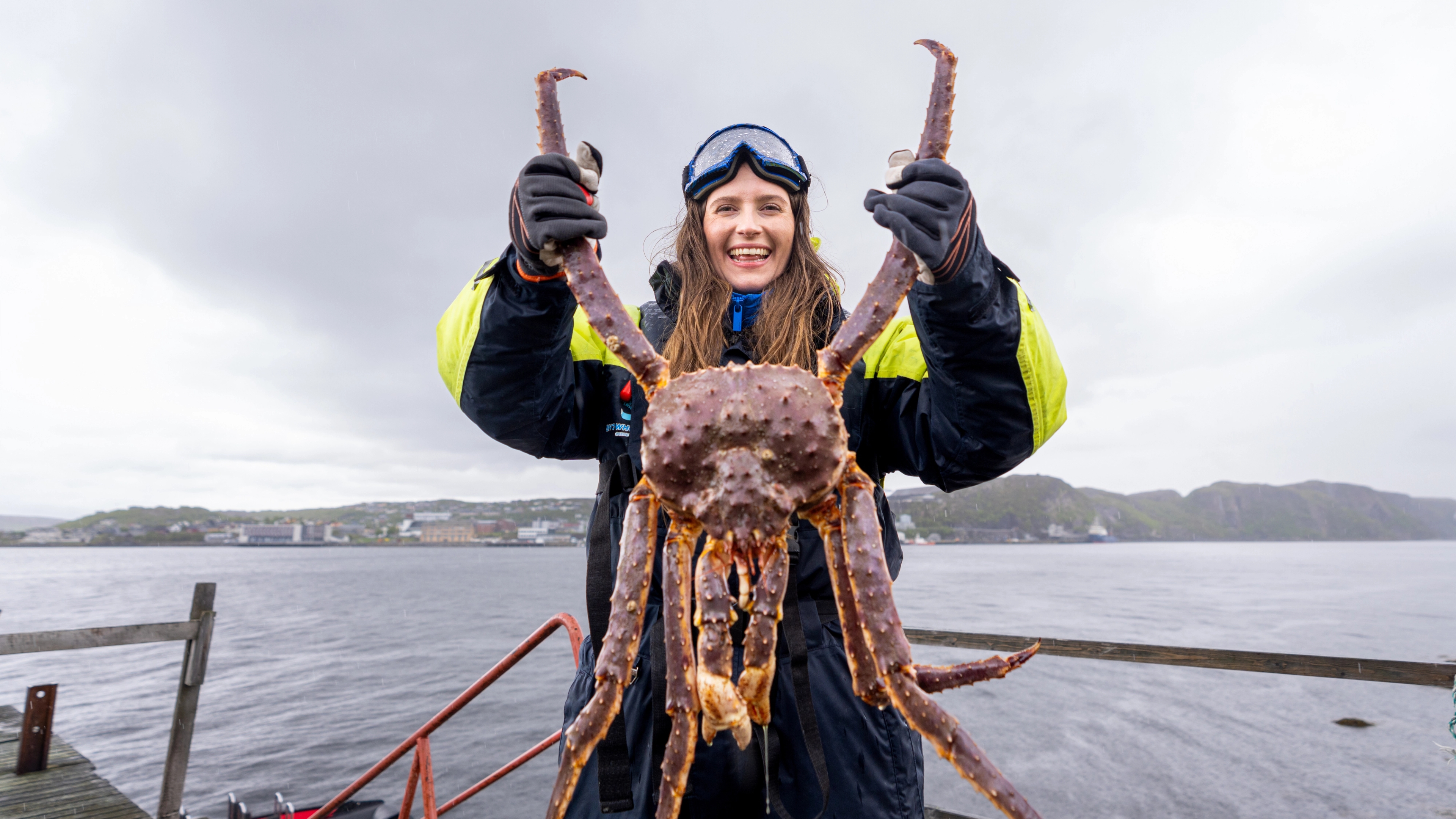A woman holding a king crab on a king crab safari outside of Kirkenes, Northern Norway