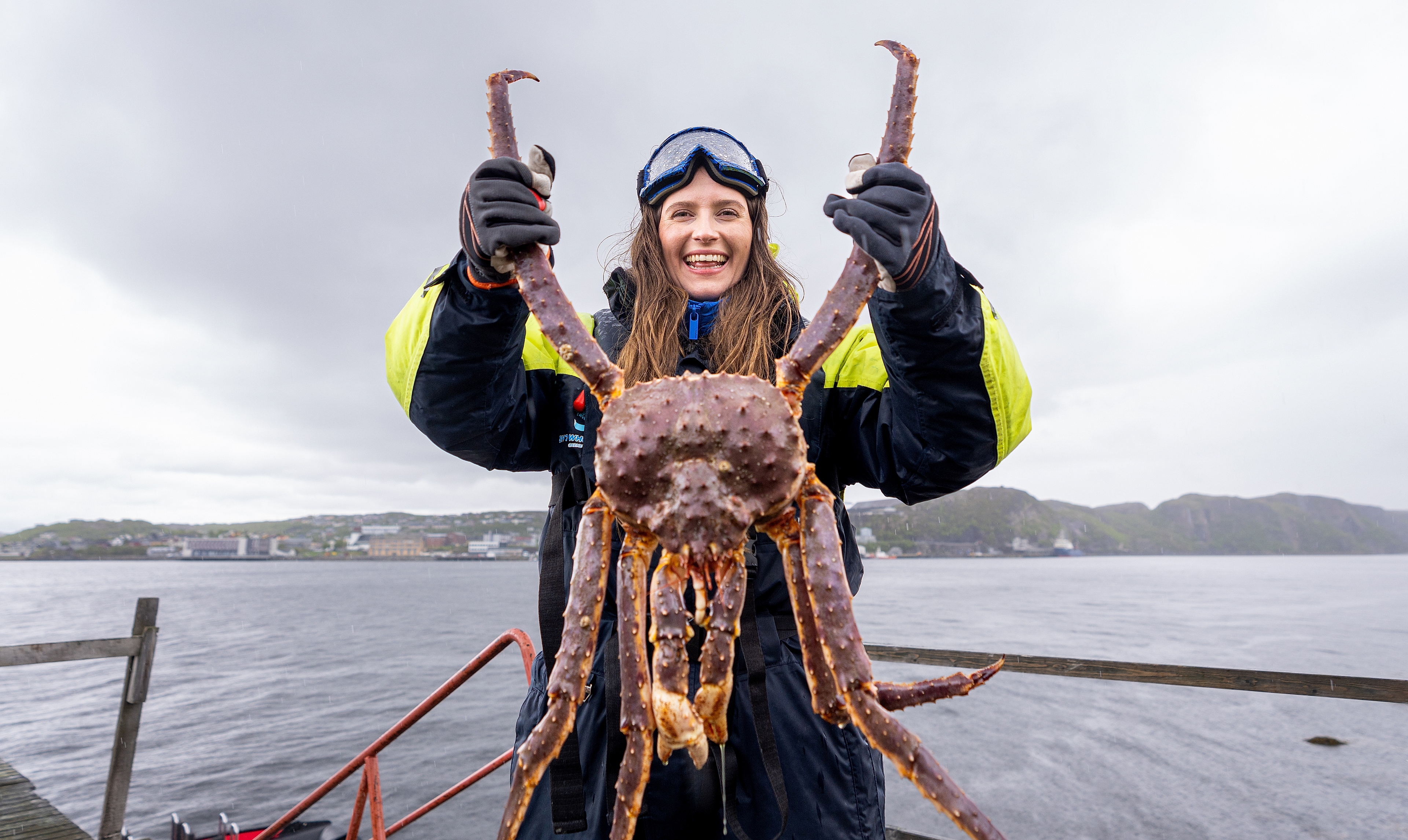 A woman holding a king crab on a king crab safari outside of Kirkenes, Northern Norway