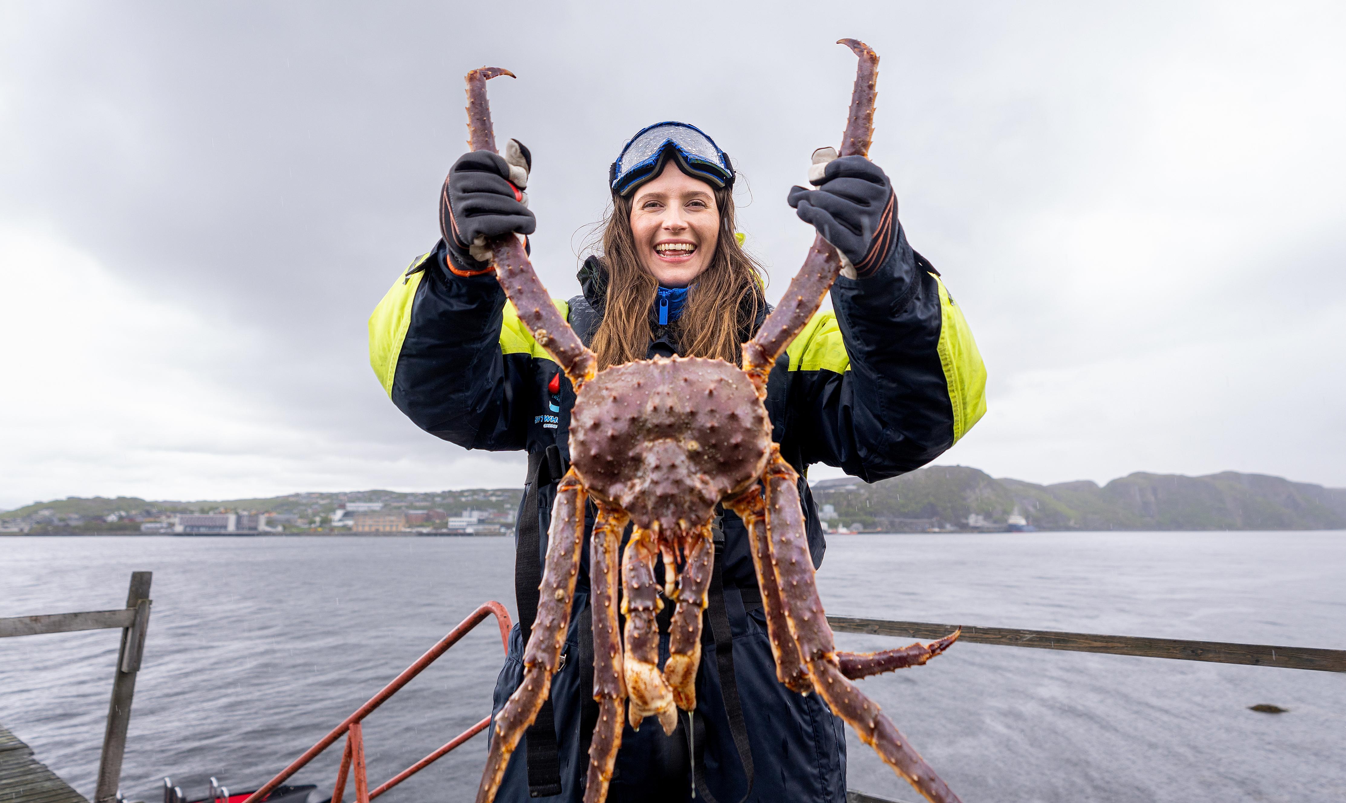 A woman holding a king crab on a king crab safari outside of Kirkenes, Northern Norway