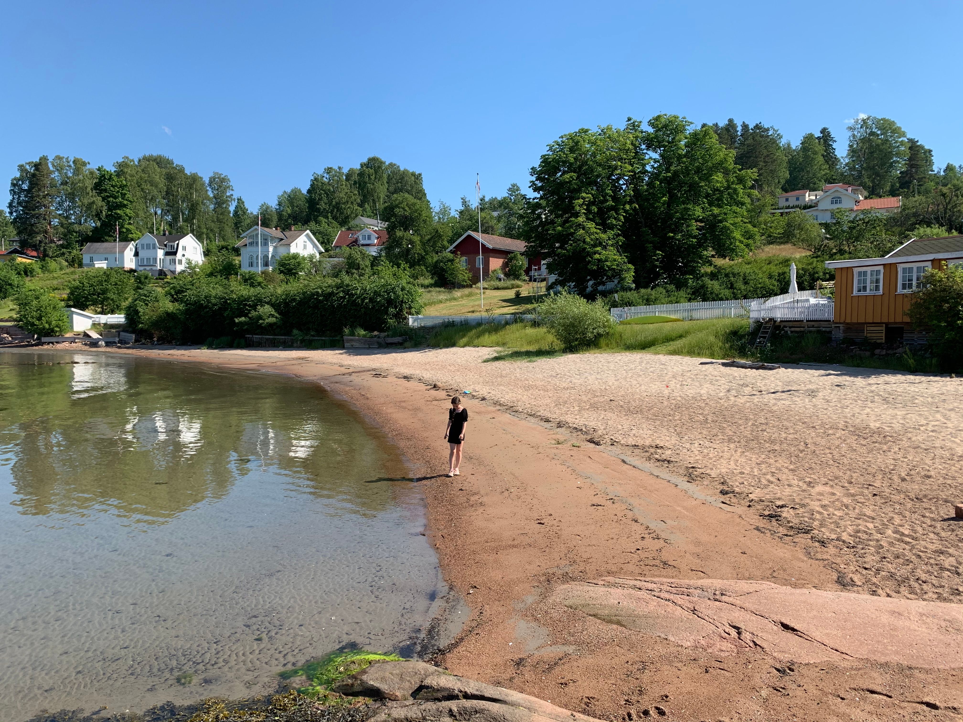 A girl is standing on the beach in Rødtangen outside of Holmsbu by the Oslofjord in Eastern Norway