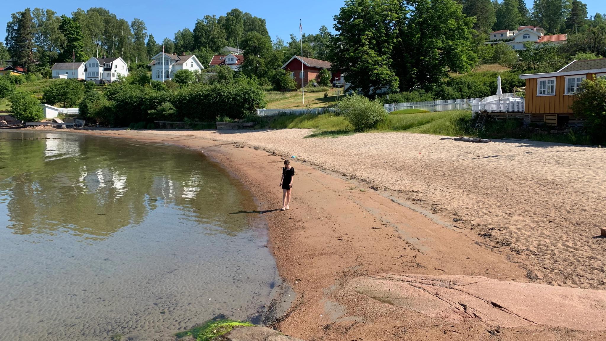 A girl is standing on the beach in Rødtangen outside of Holmsbu by the Oslofjord in Eastern Norway