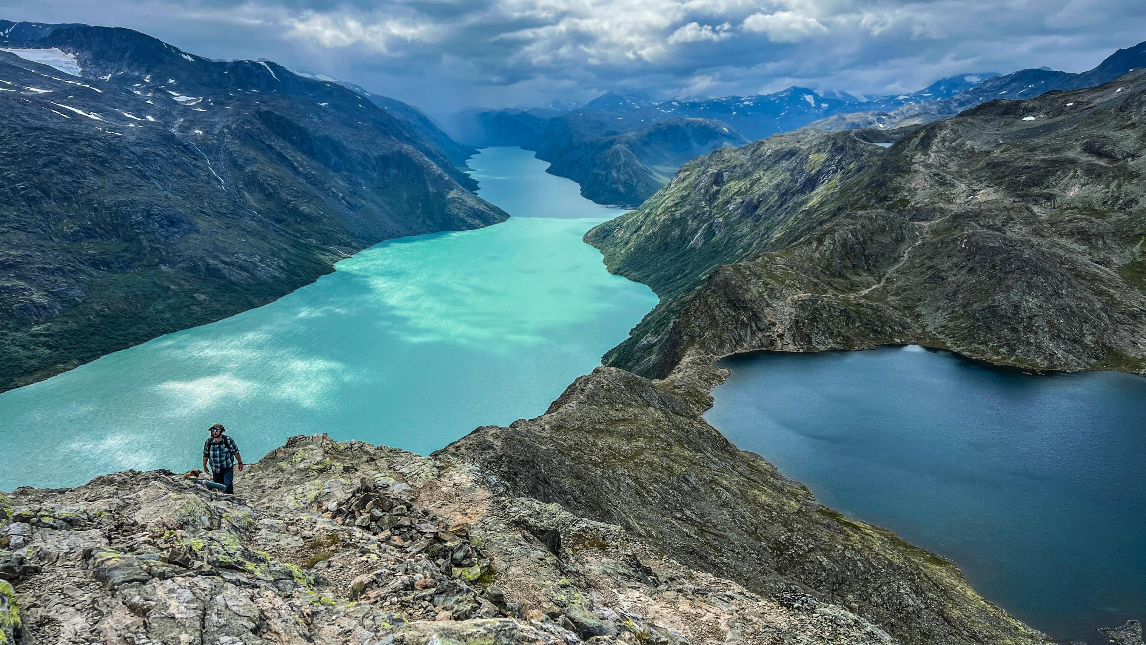 People hiking a mountain by a lake
