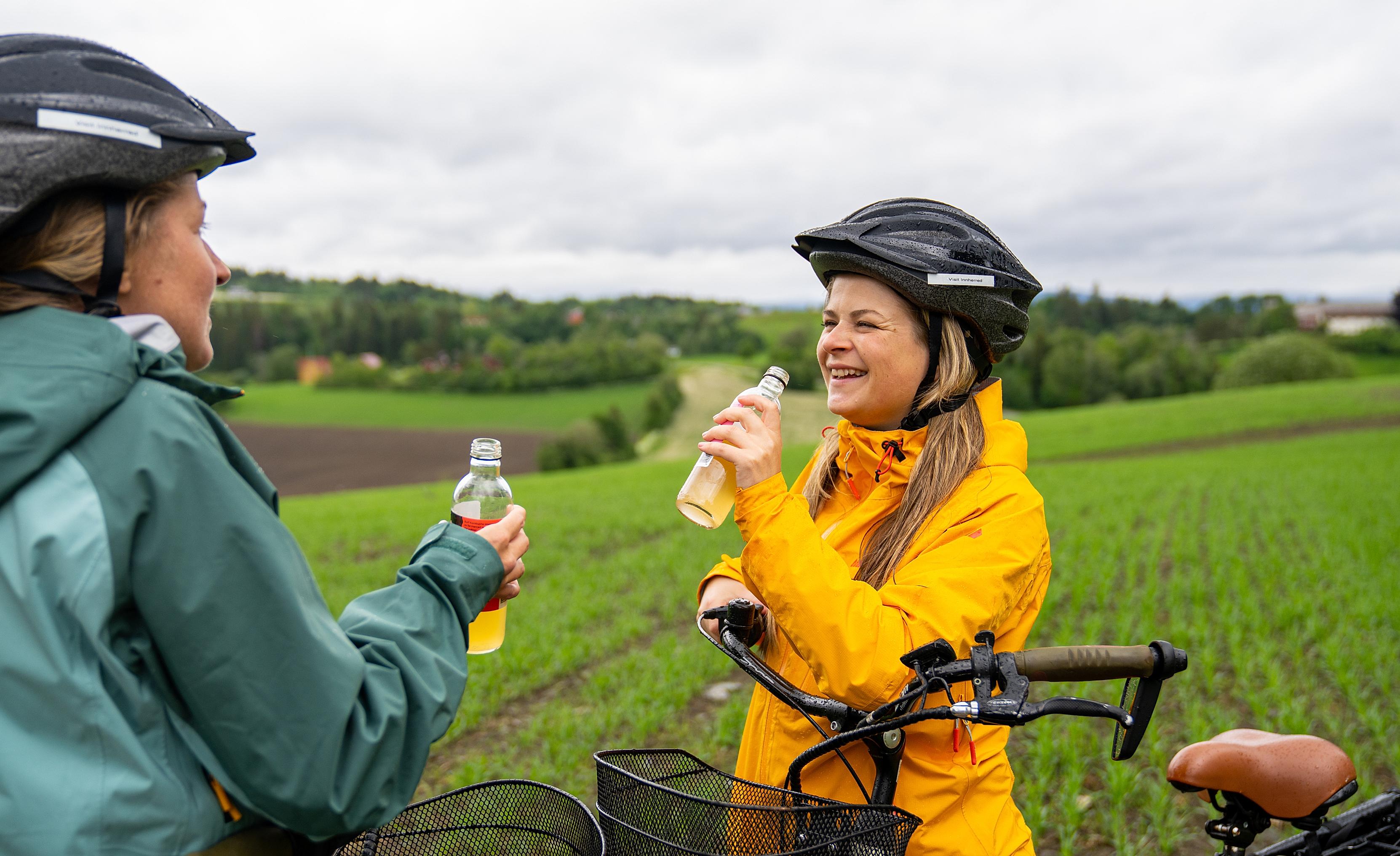 Two woman enjoying a juice from the bicycle seat