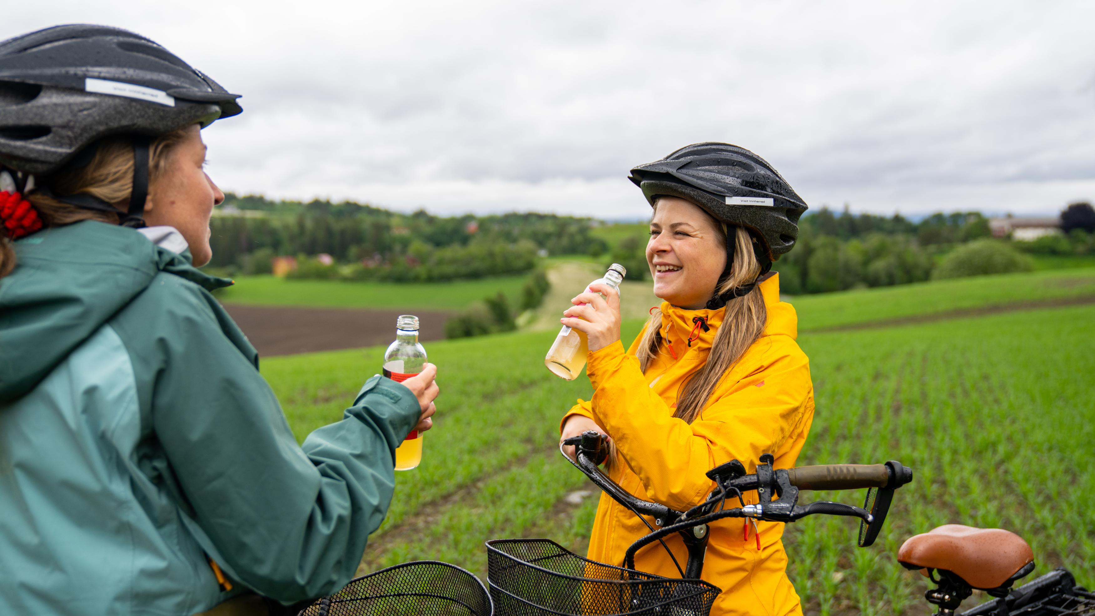 Two woman enjoying a juice from the bicycle seat