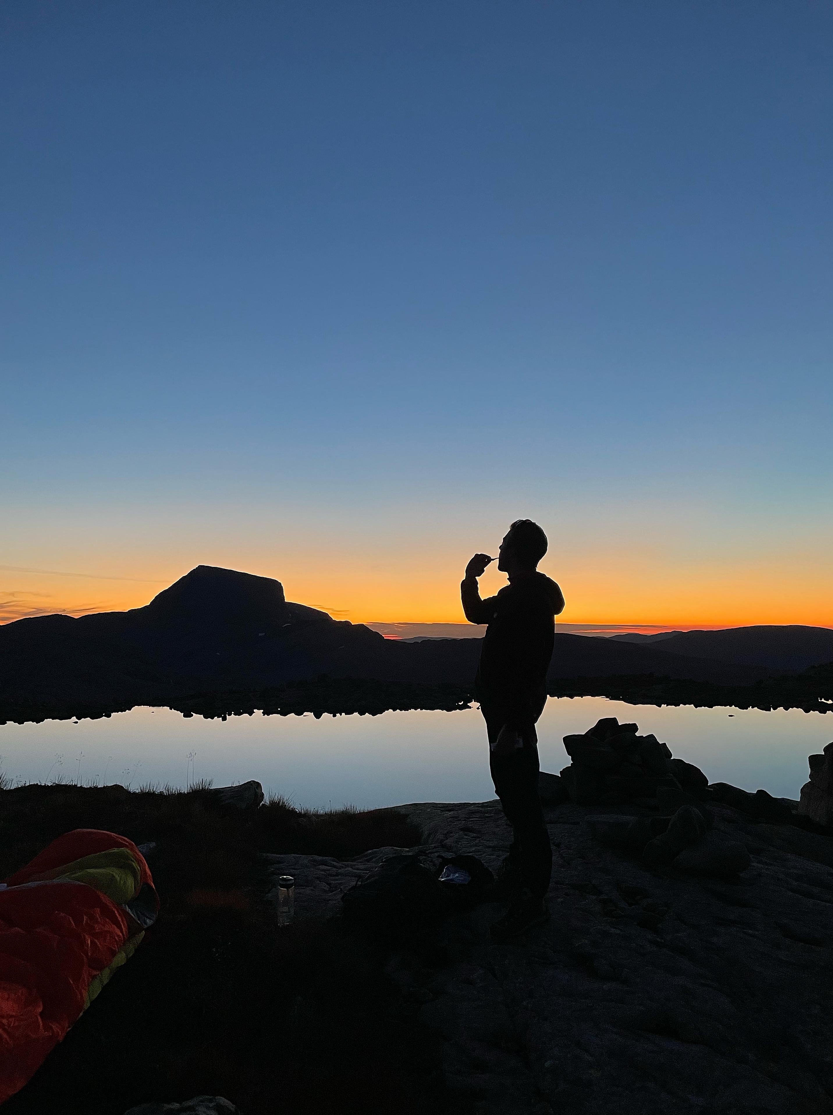 A man brushing his teeth in the sunset in Ålfoten, Nordfjord