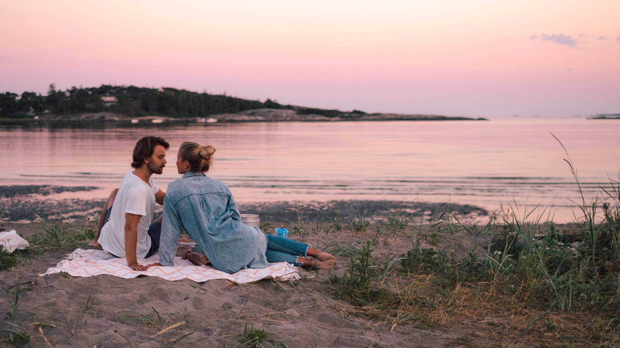 En romantisk piknik i solnedgangen på en strand i Fredrikstad