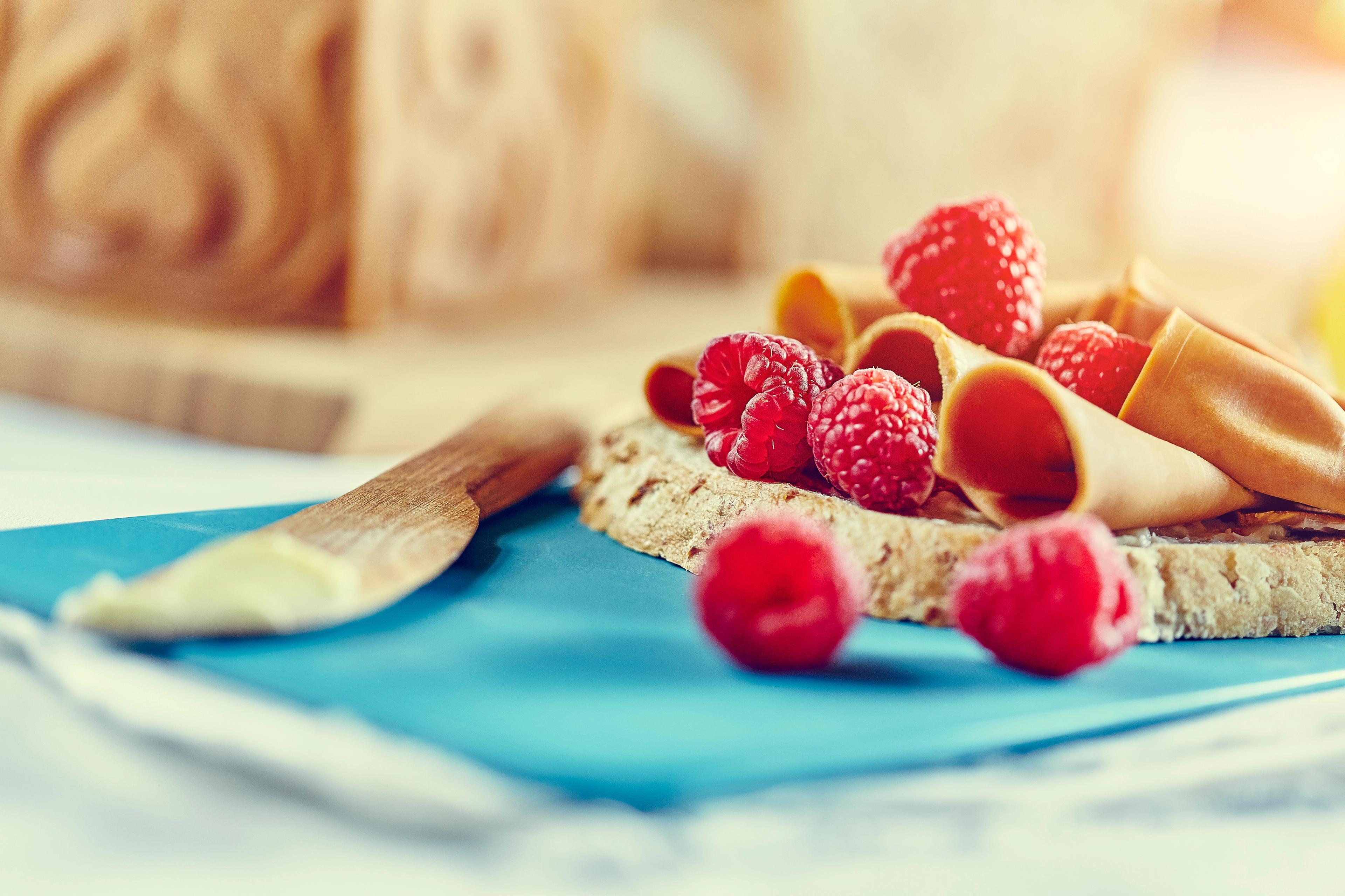 A slice of bread with brown cheese and berries in Norway