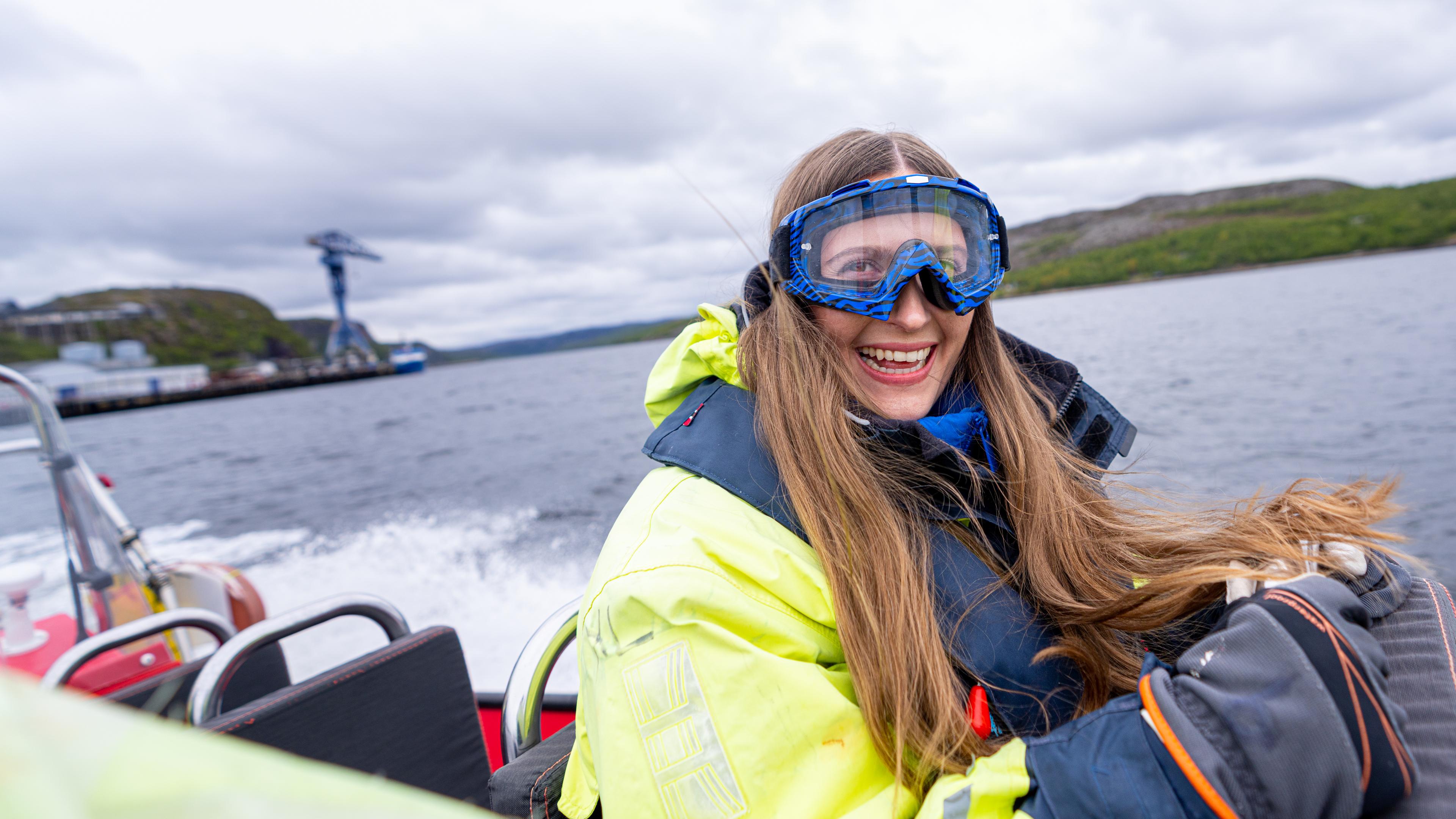 A happy woman riding a rib boat outside of Kirkenes, Northern Norway.