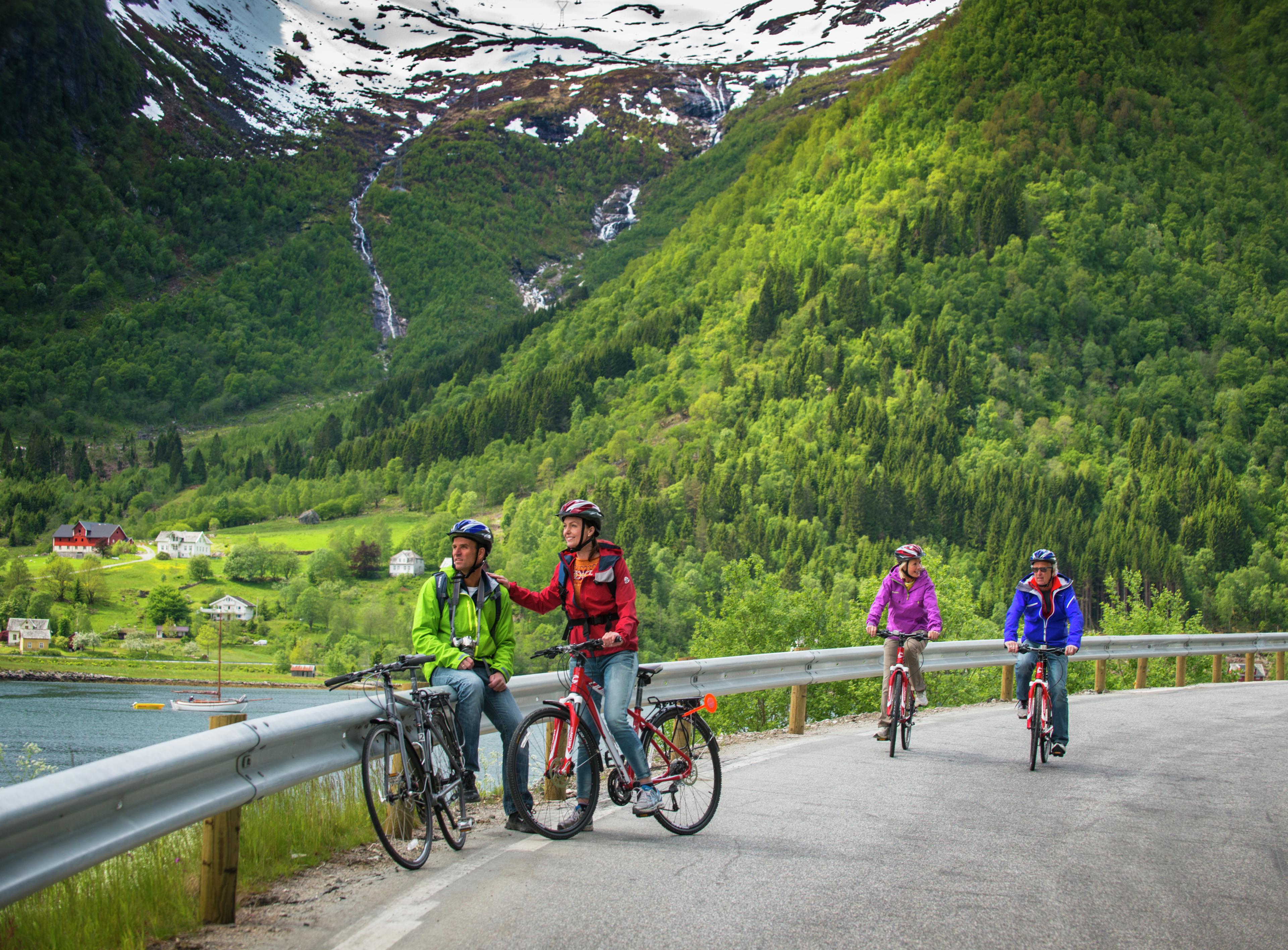 Personer cykler på en vej i Balestrand, Fjord Norge