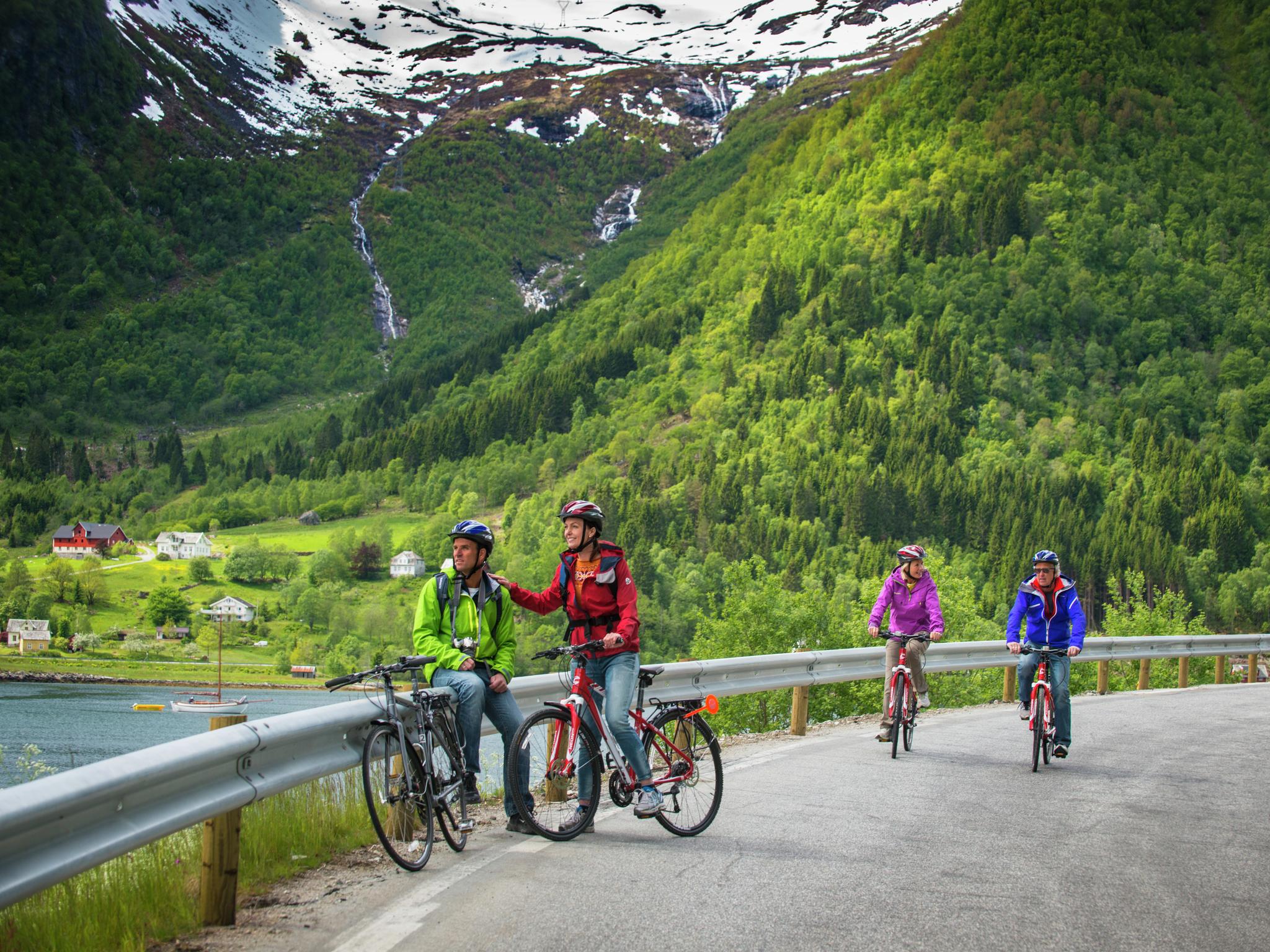 People cycling on a road in Balestrand, Fjord Norway