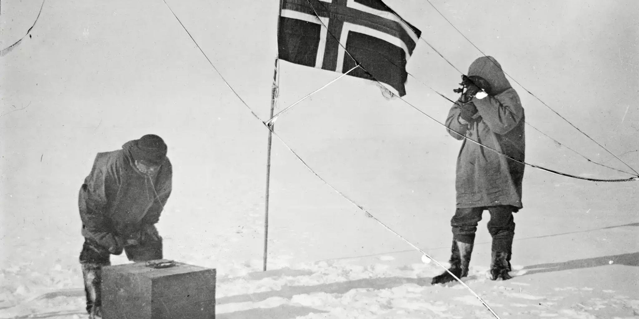 Roald Amundsen and Helmer Hanssen next to a Norwegian flag at the South Pole in 1911