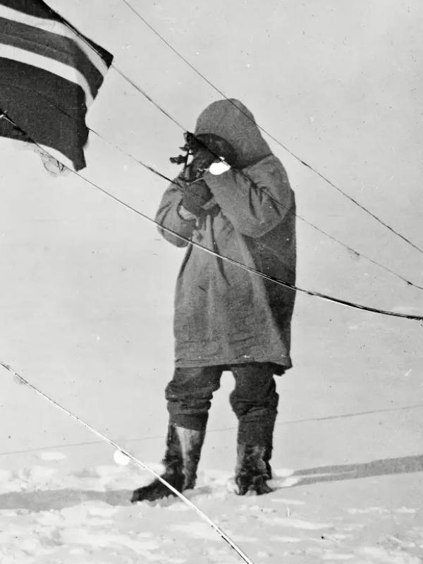 Roald Amundsen and Helmer Hanssen next to a Norwegian flag at the South Pole in 1911