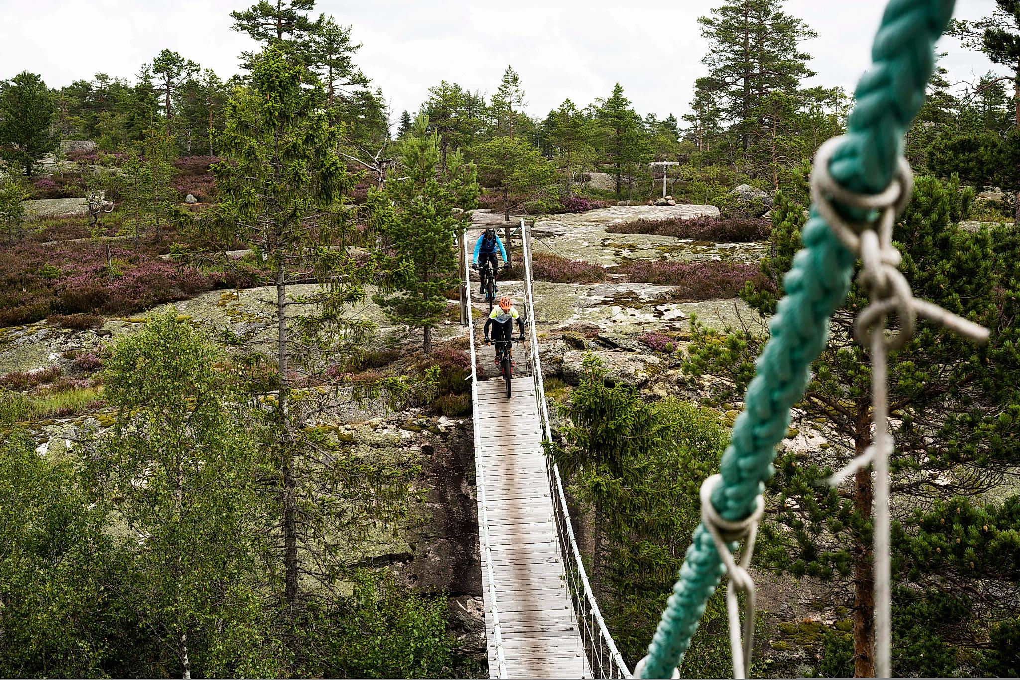 Deux vététistes traversant un pont dans la commune de Nissedal dans le Telemark, en Norvège de l'Est