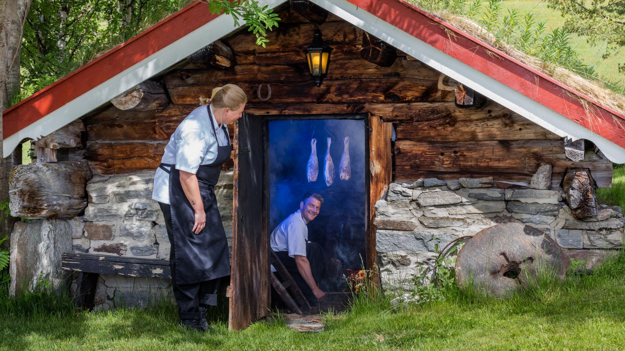 Homme fumant de la viande d’agneau dans le sauna de la ferme d'altitude Bortistu dans l’Oppdal, dans le Trøndelag