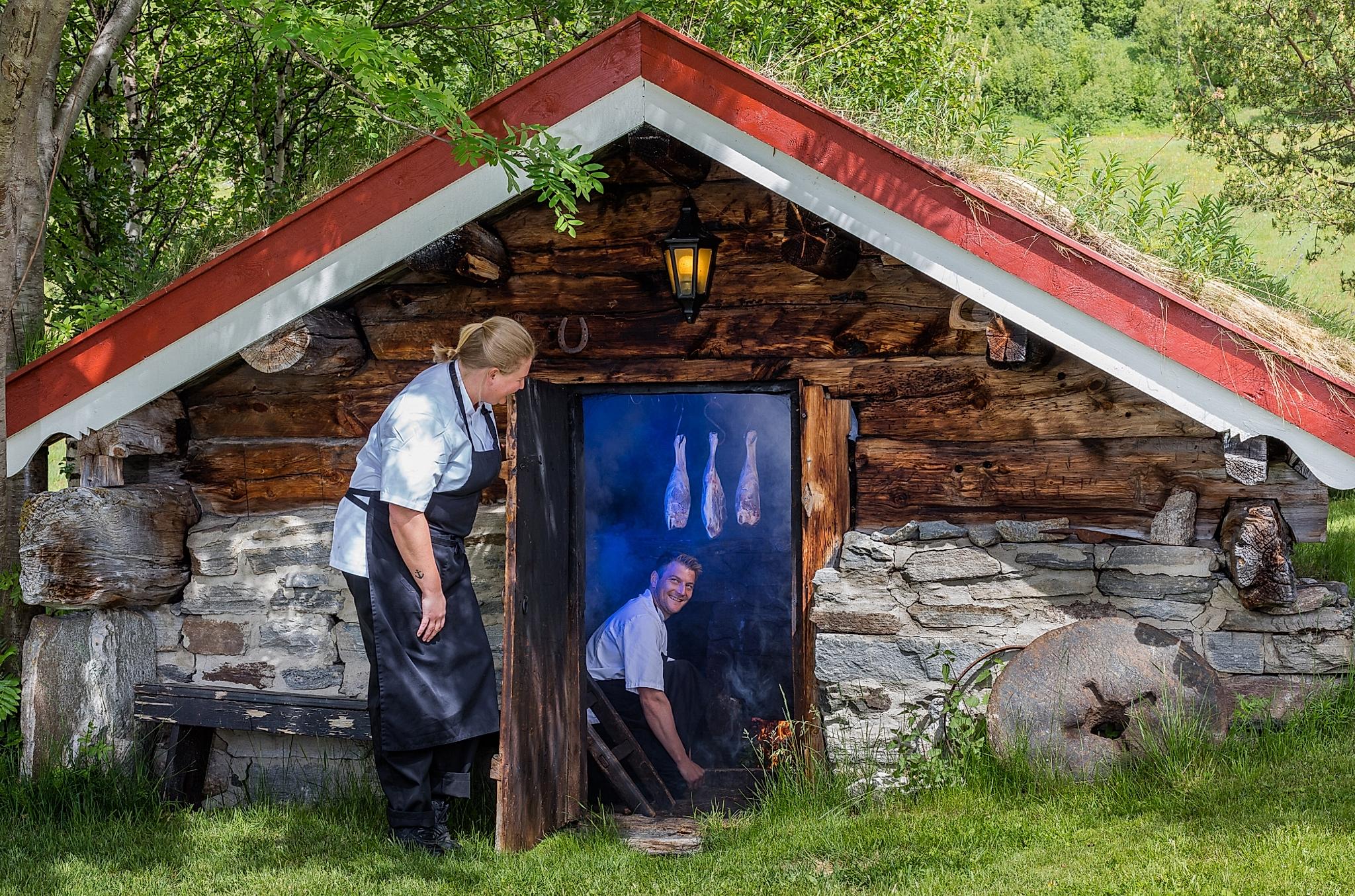 Un uomo prepara la carne d’agnello affumicata in una camera di affumicatura a Bortistu Gjestegard nell’Oppdal, Trøndelag