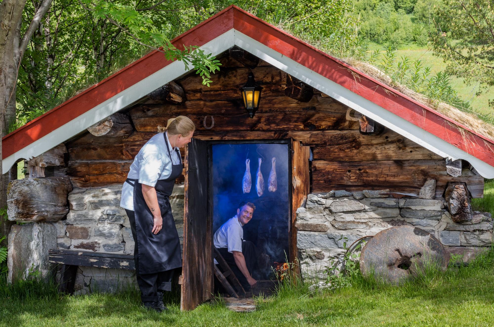 Imagen de un hombre ahumando cordero en el interior de una sauna en la granja de montaña Bortistu, en Oppdal, Trøndelag.
