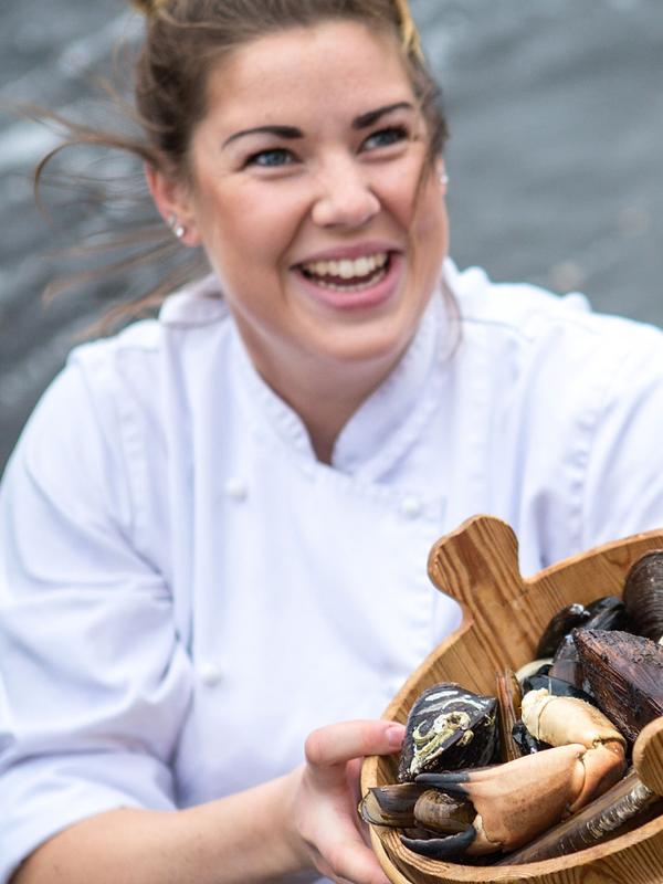 A renowned chef holding a bucket of fresh seafood from Fosen in Trøndelag