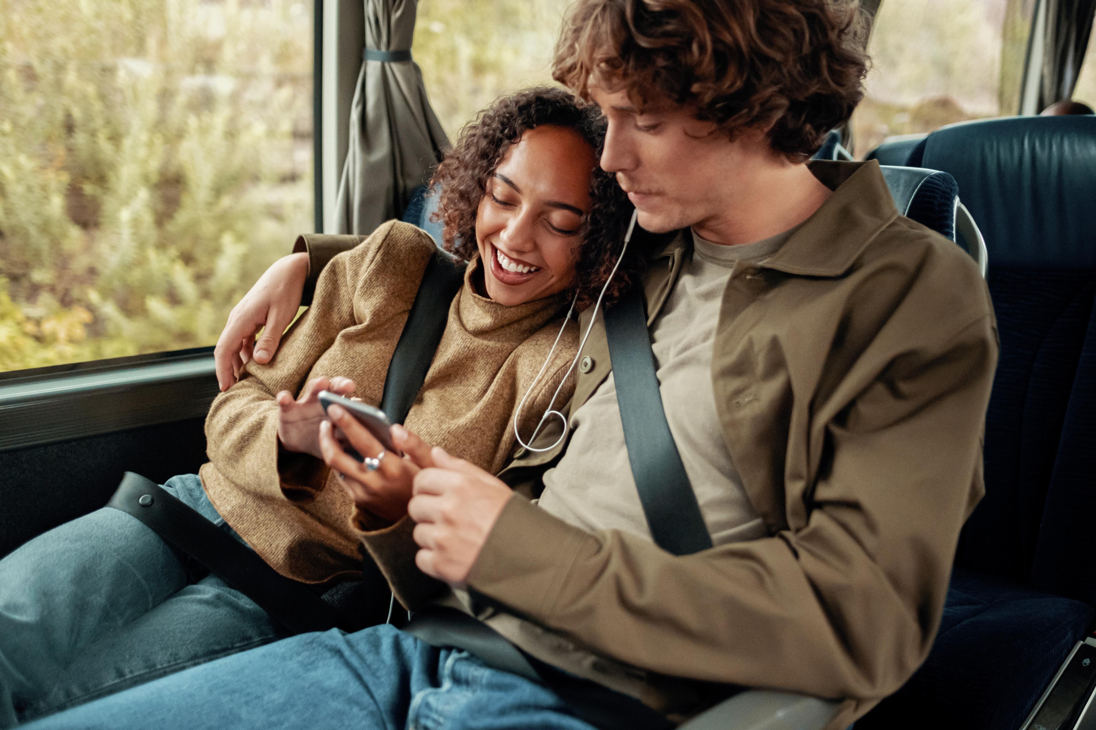 A woman and a man riding a bus in Norway.