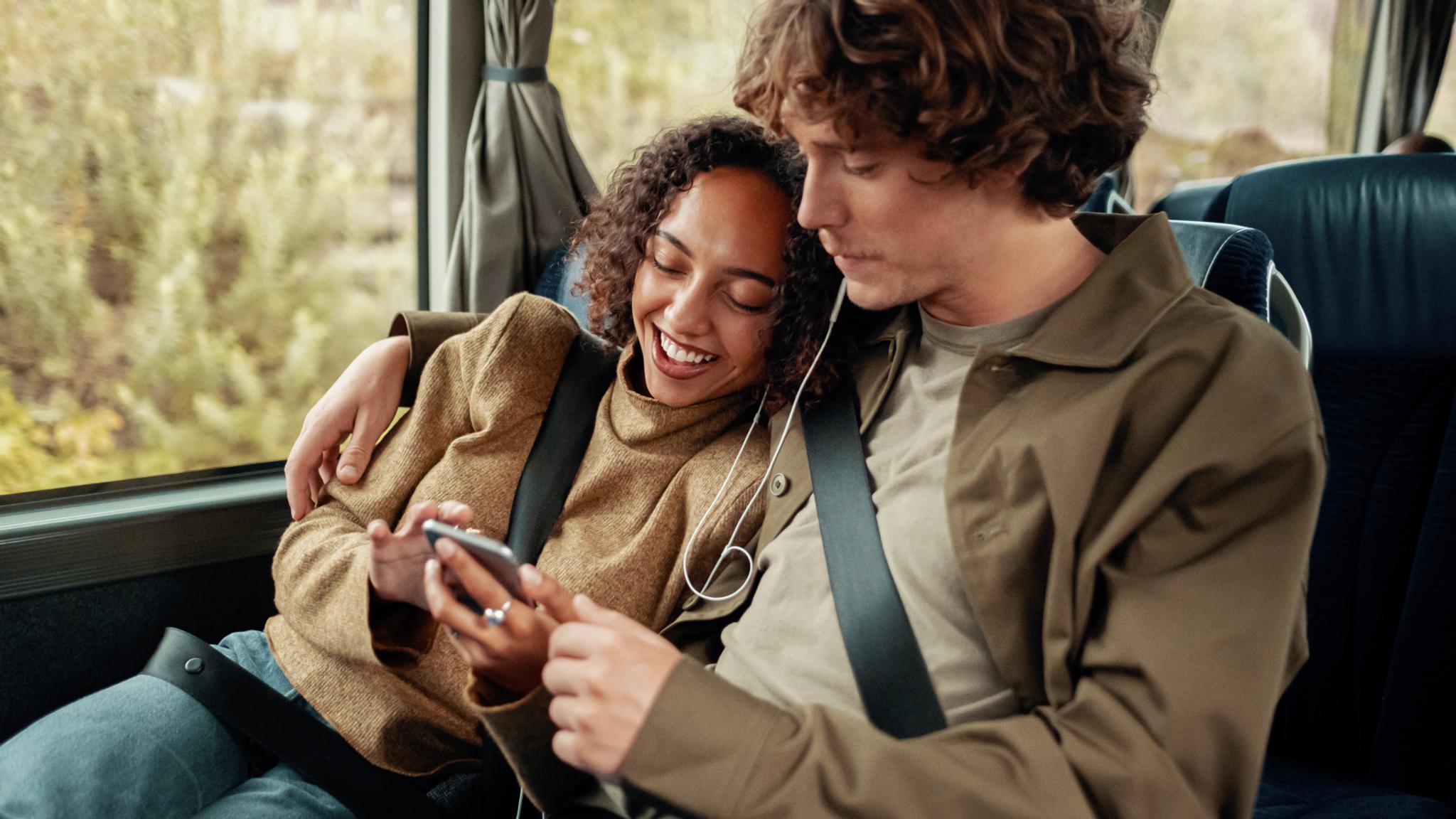 A woman and a man riding a bus in Norway.