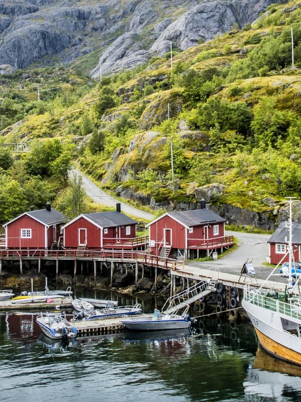 Boats and red fisherman's cabins along the small harbour of Nusfjord in Lofoten, Northern Norway