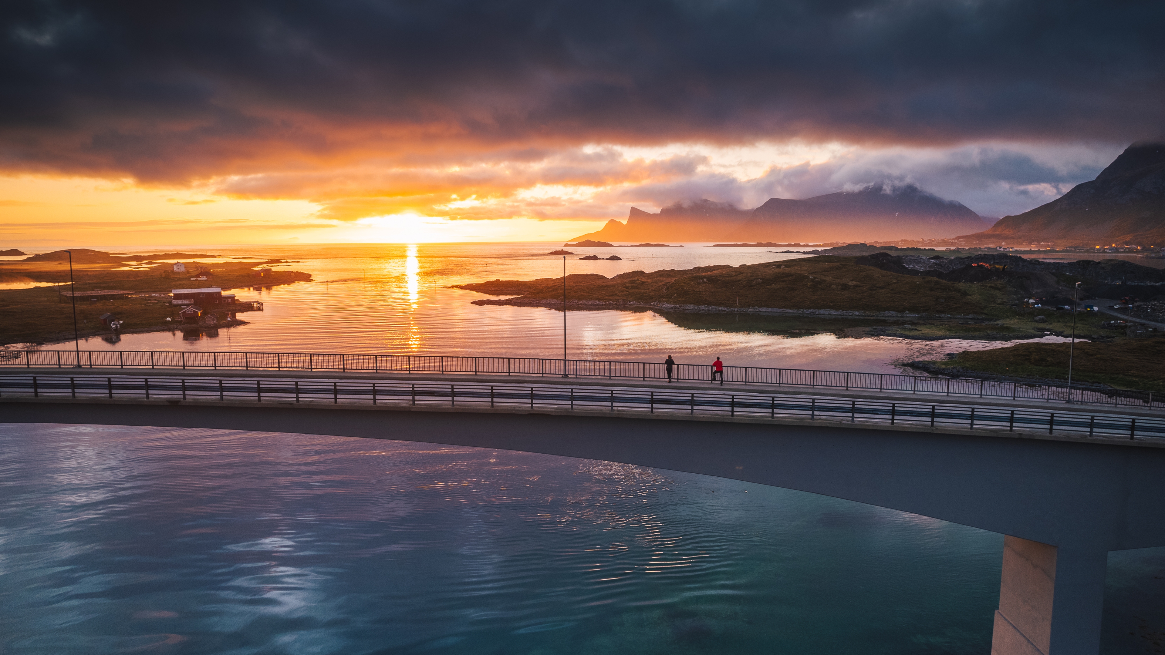 Two people exploring Lofoten under the midnight sun