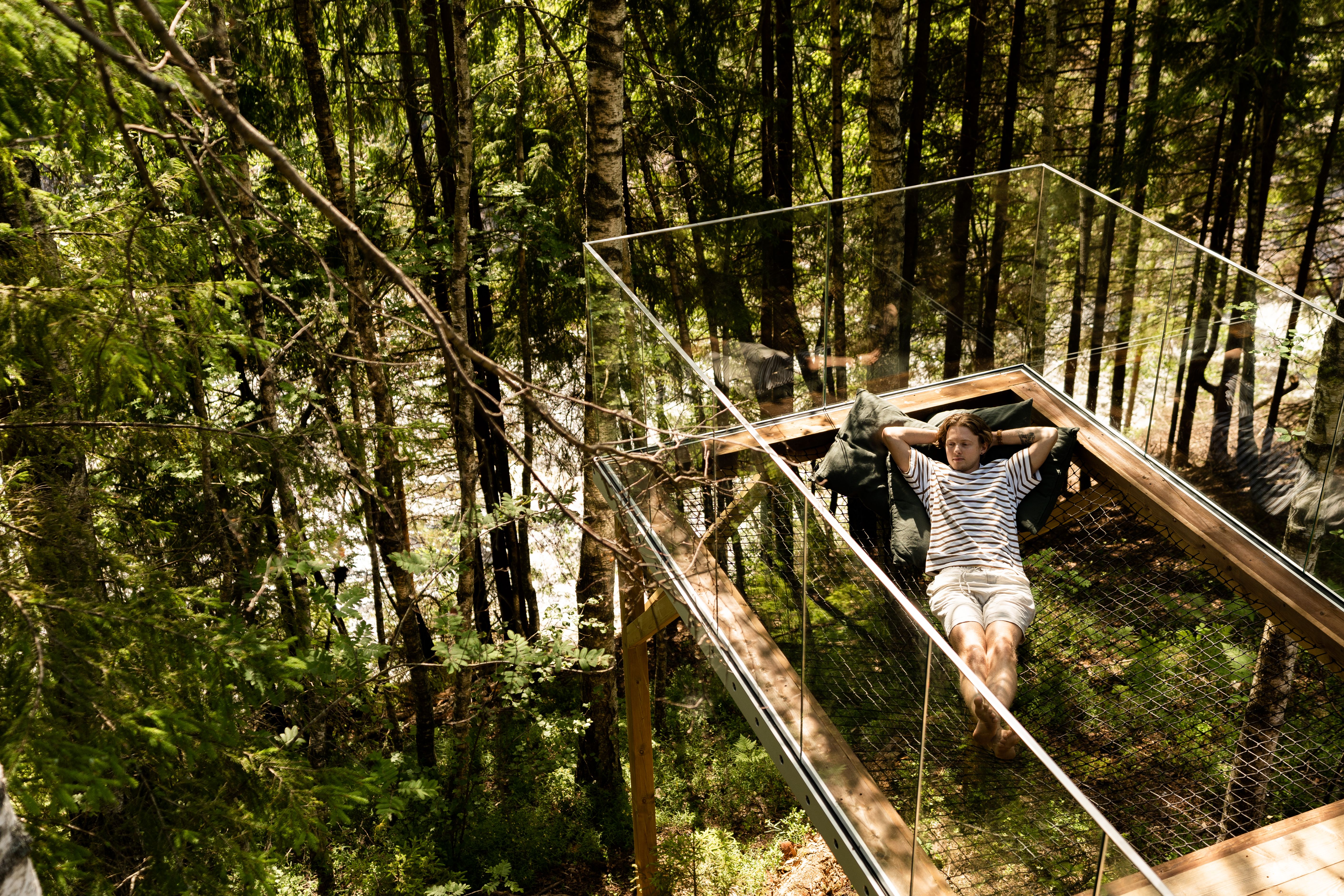 Man enjoying the calming nature from the treetop cabin in Laagen, Larvik