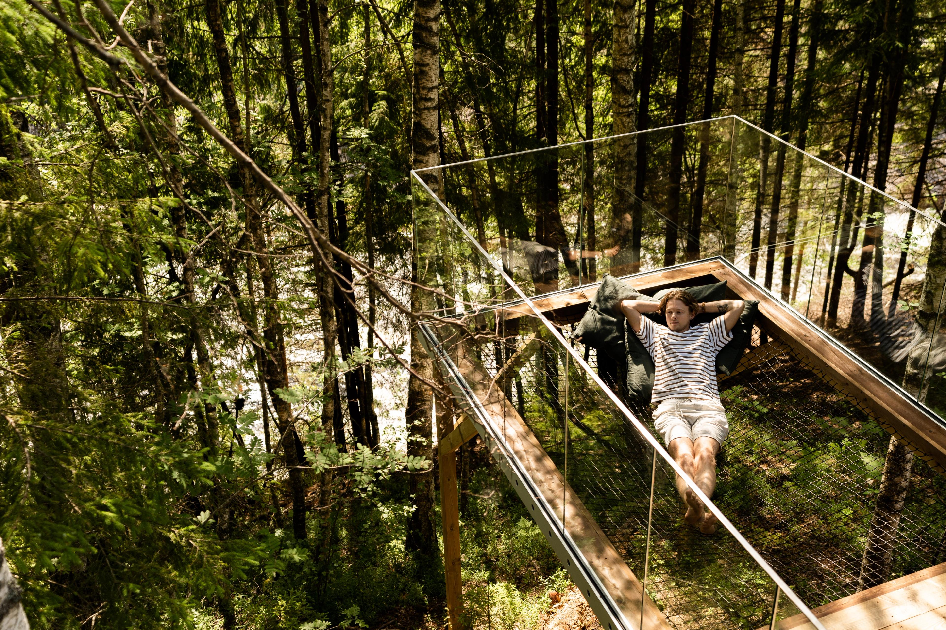 Man enjoying the calming nature from the treetop cabin in Laagen, Larvik