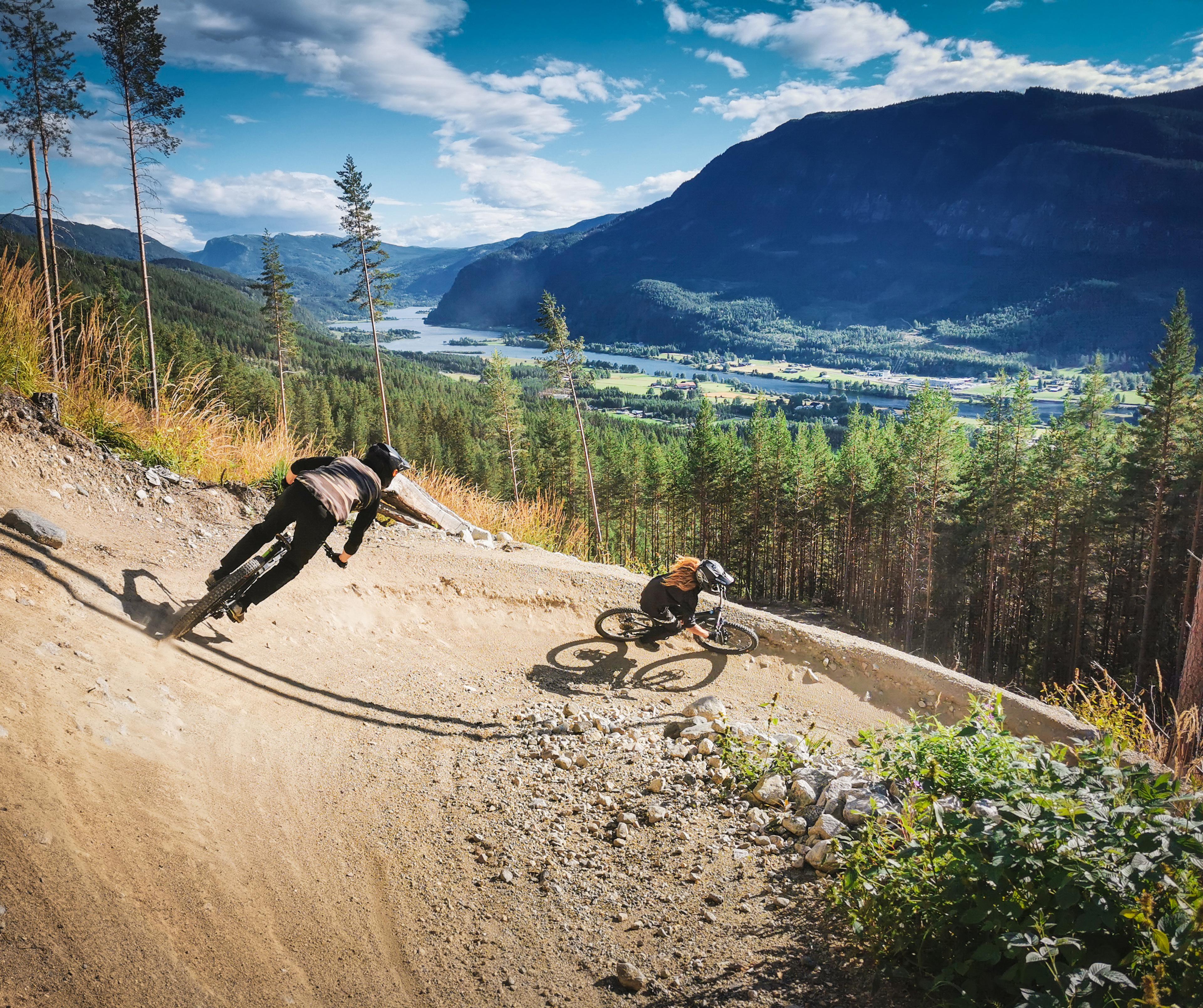 Two people cycling down Den Ravinde in Nesbyen, Eastern Norway.