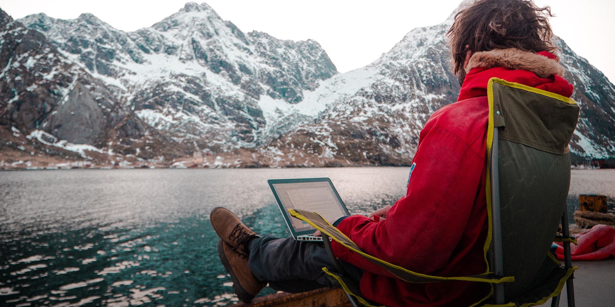 A man working outdoors by the sea at the Arctic Coworking Lodge in Lofoten, Northern Noway