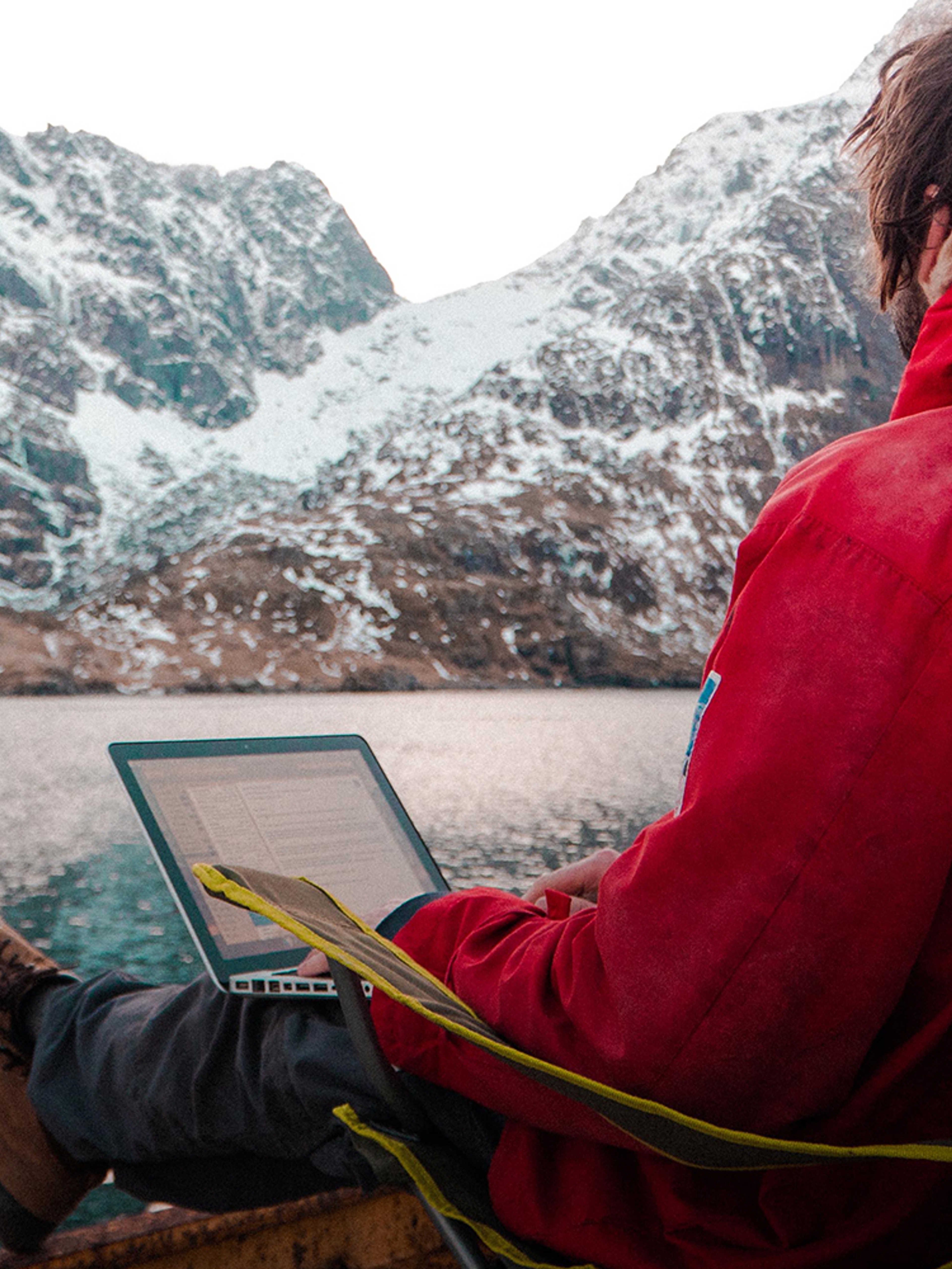 A man working outdoors by the sea at the Arctic Coworking Lodge in Lofoten, Northern Noway