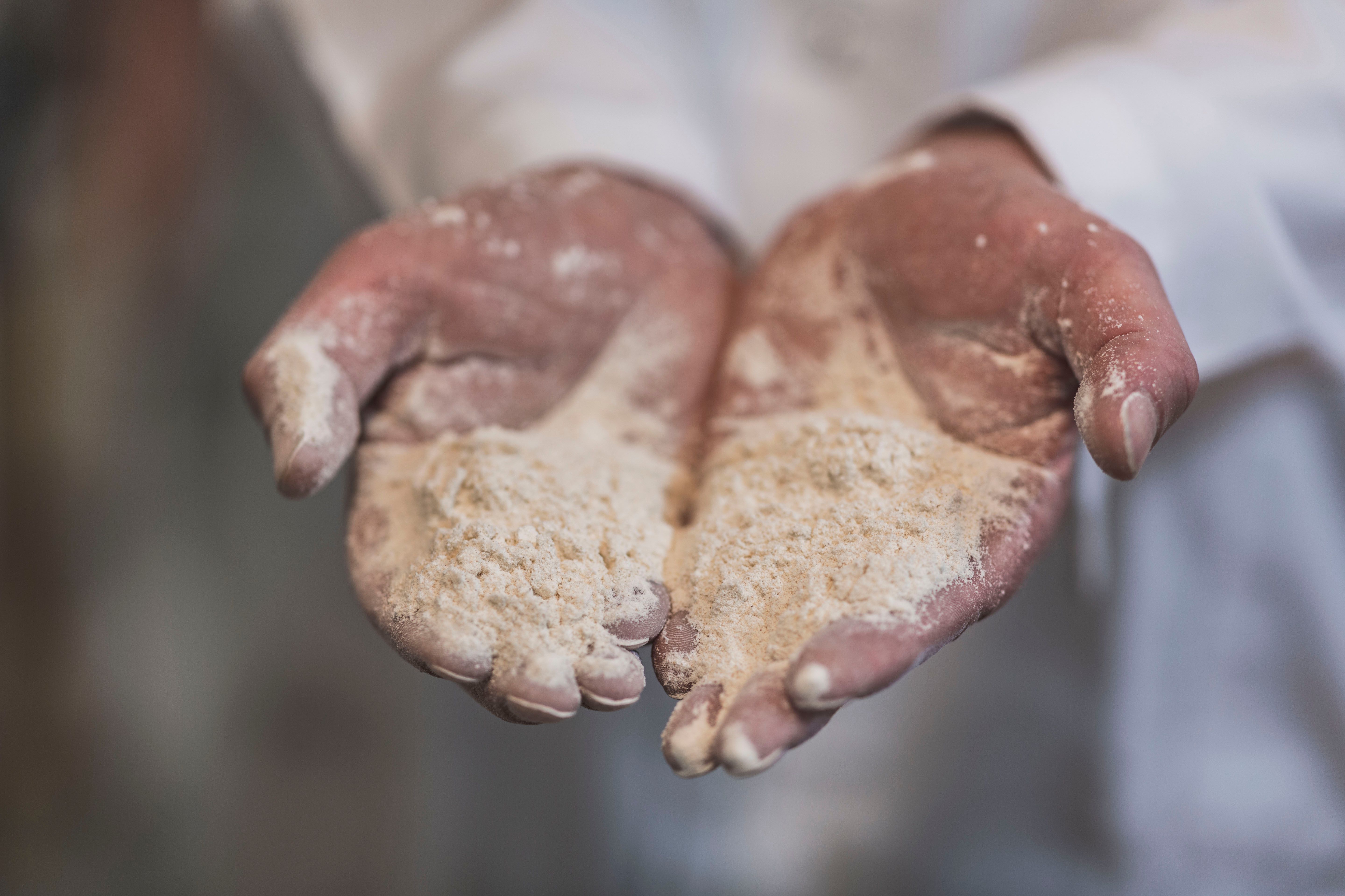 A person is holding up Norwegian flour in his hands