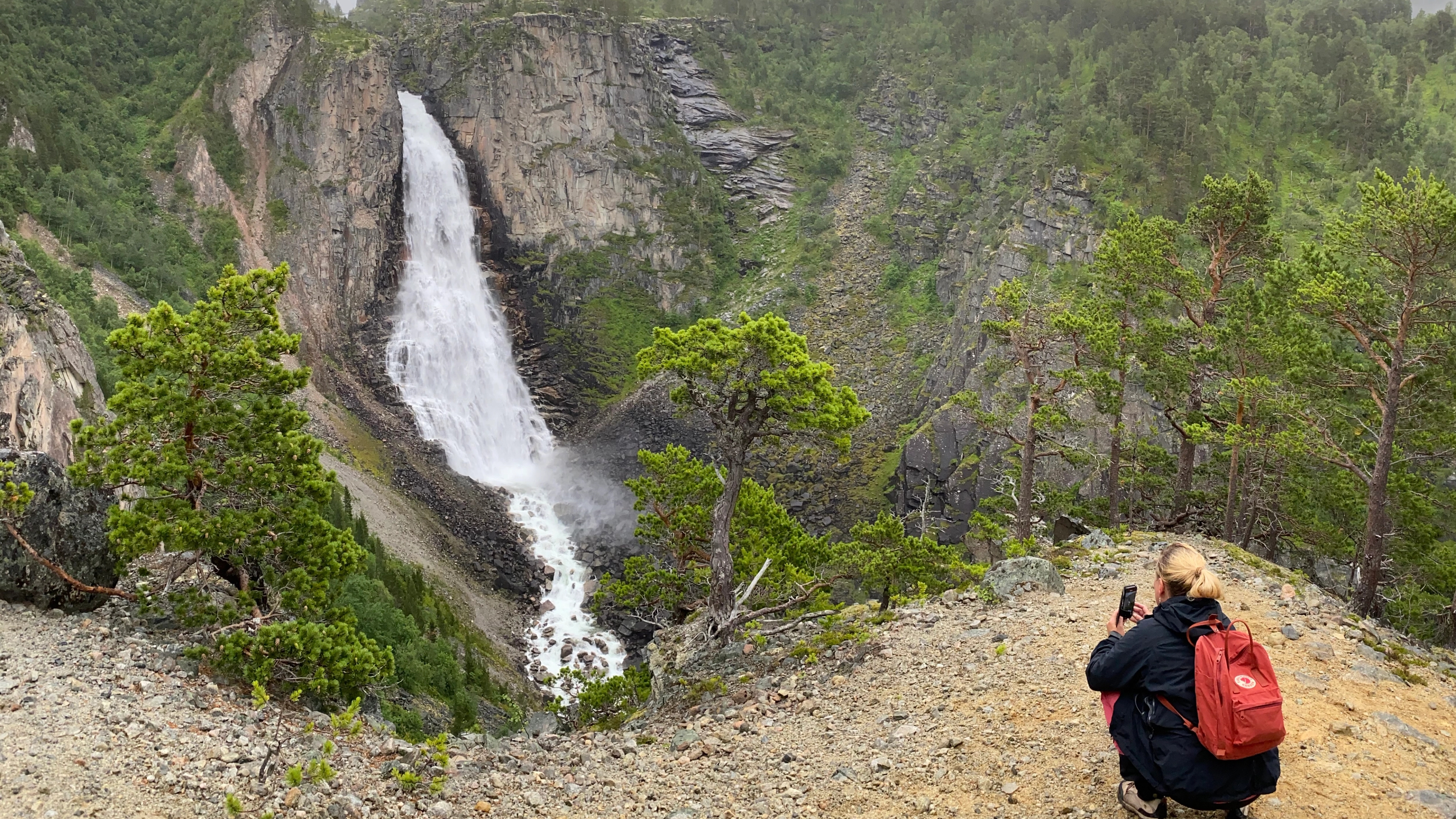 A woman by the Lindisfallet waterfall in Åmotan