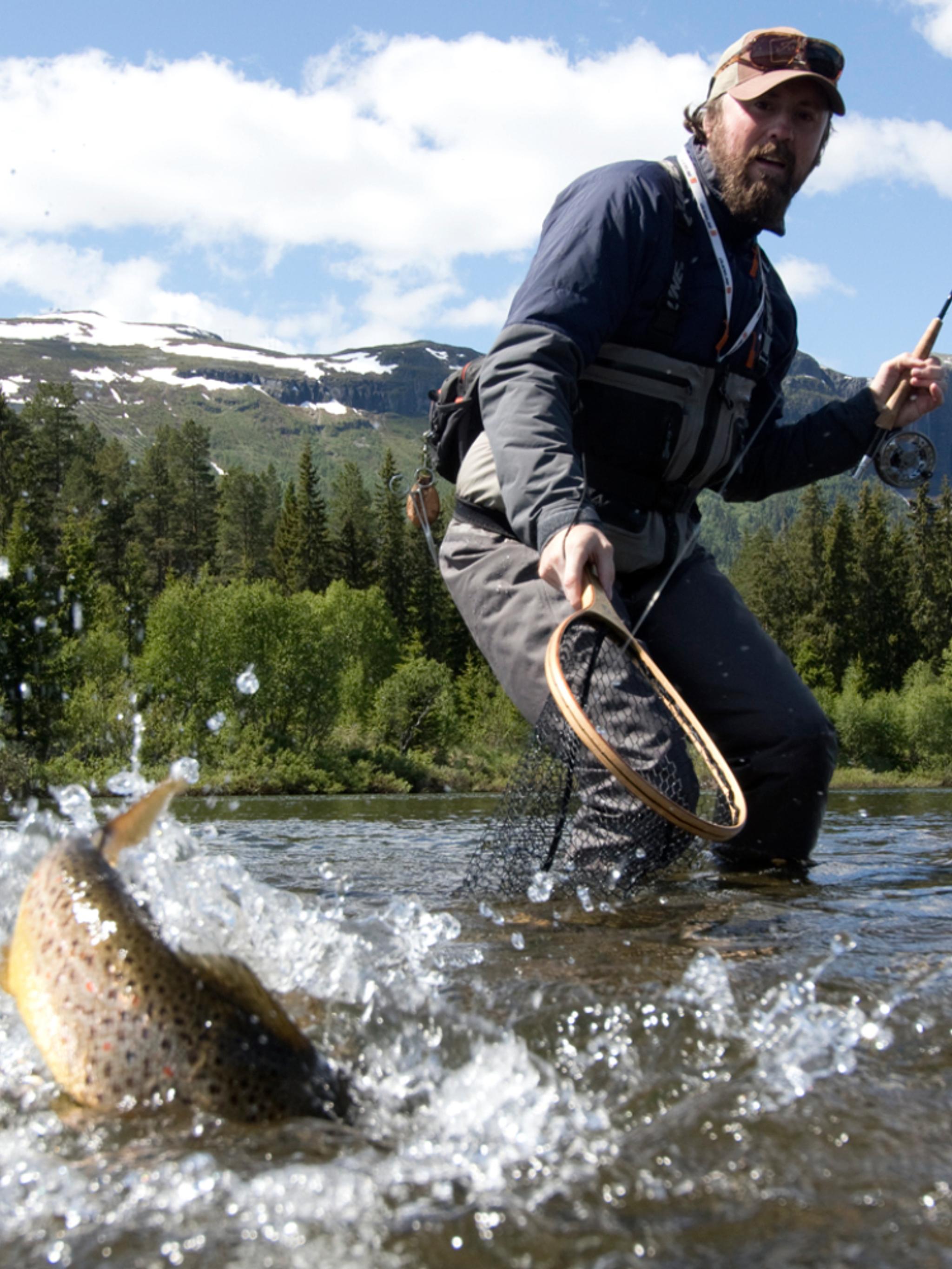 A man catching a fish in a river in Hemsedal, Eastern Norway