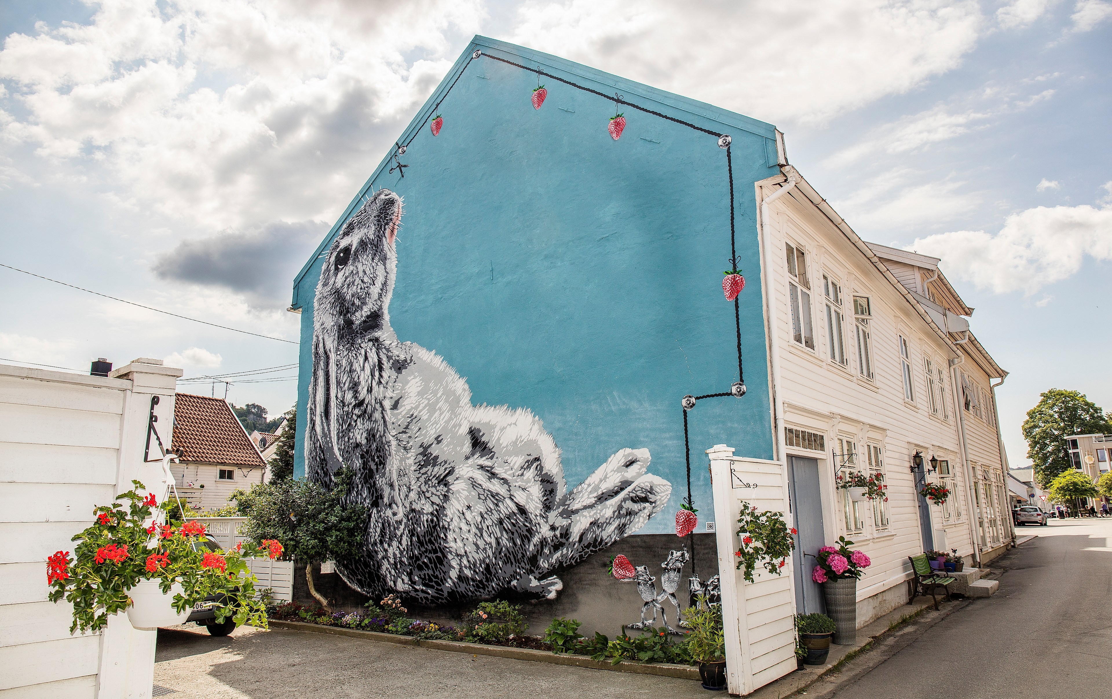 Gatekunst som dekker hele kortsiden av et hvitt trehus i Flekkefjord på Sørlandet
