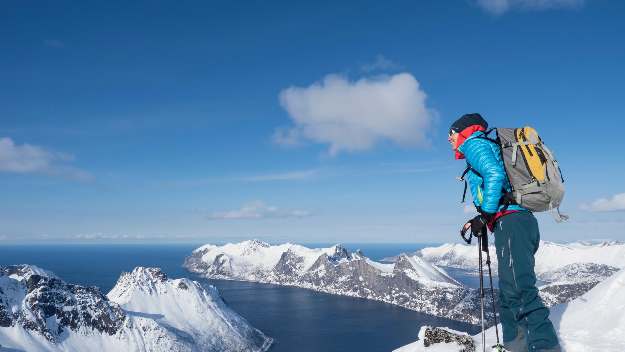 A woman standing at the top of a mountain in Senja in Northern Norway during winter