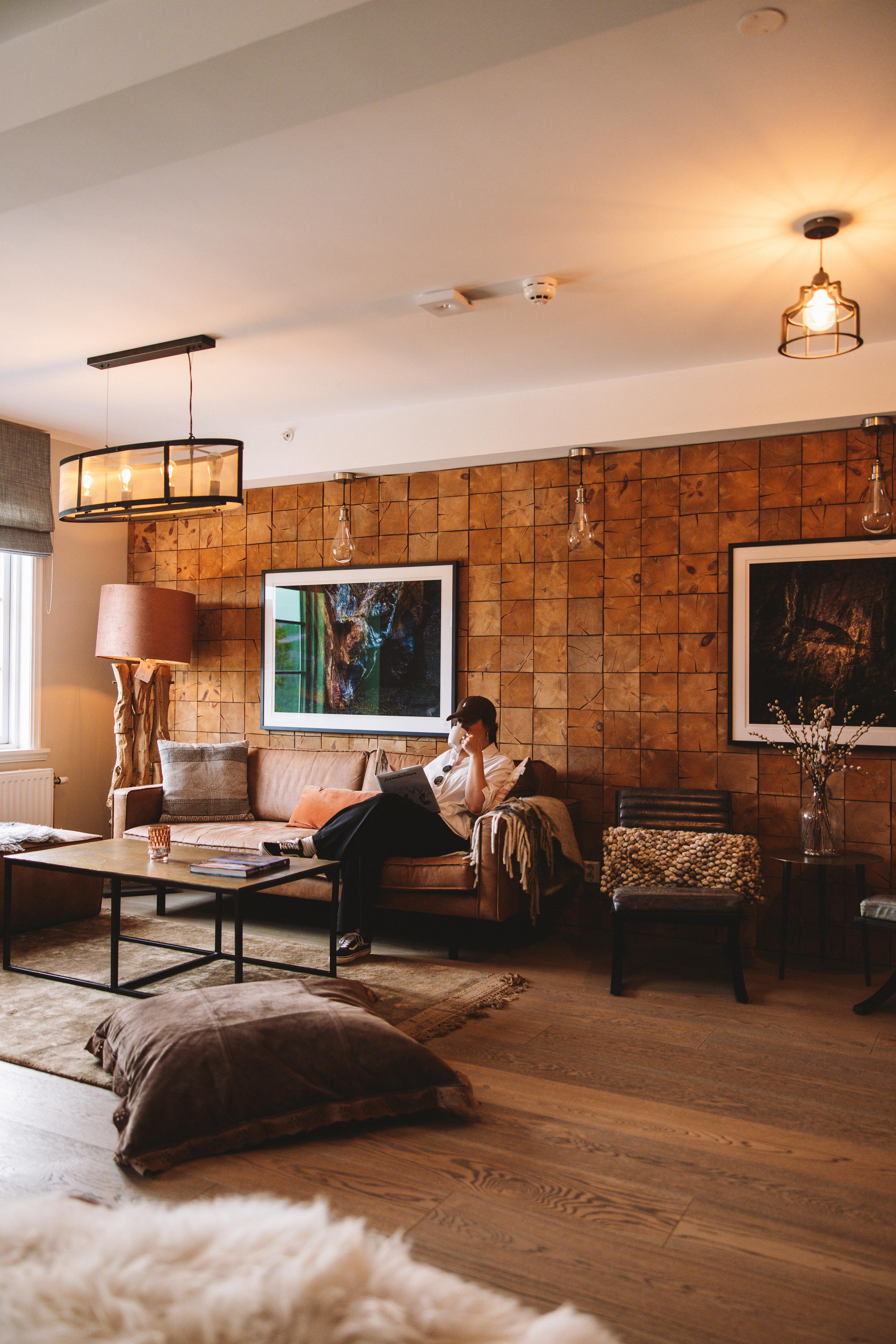 A woman sitting inside the living room at Skåbu mountain hotel in Skåbu.