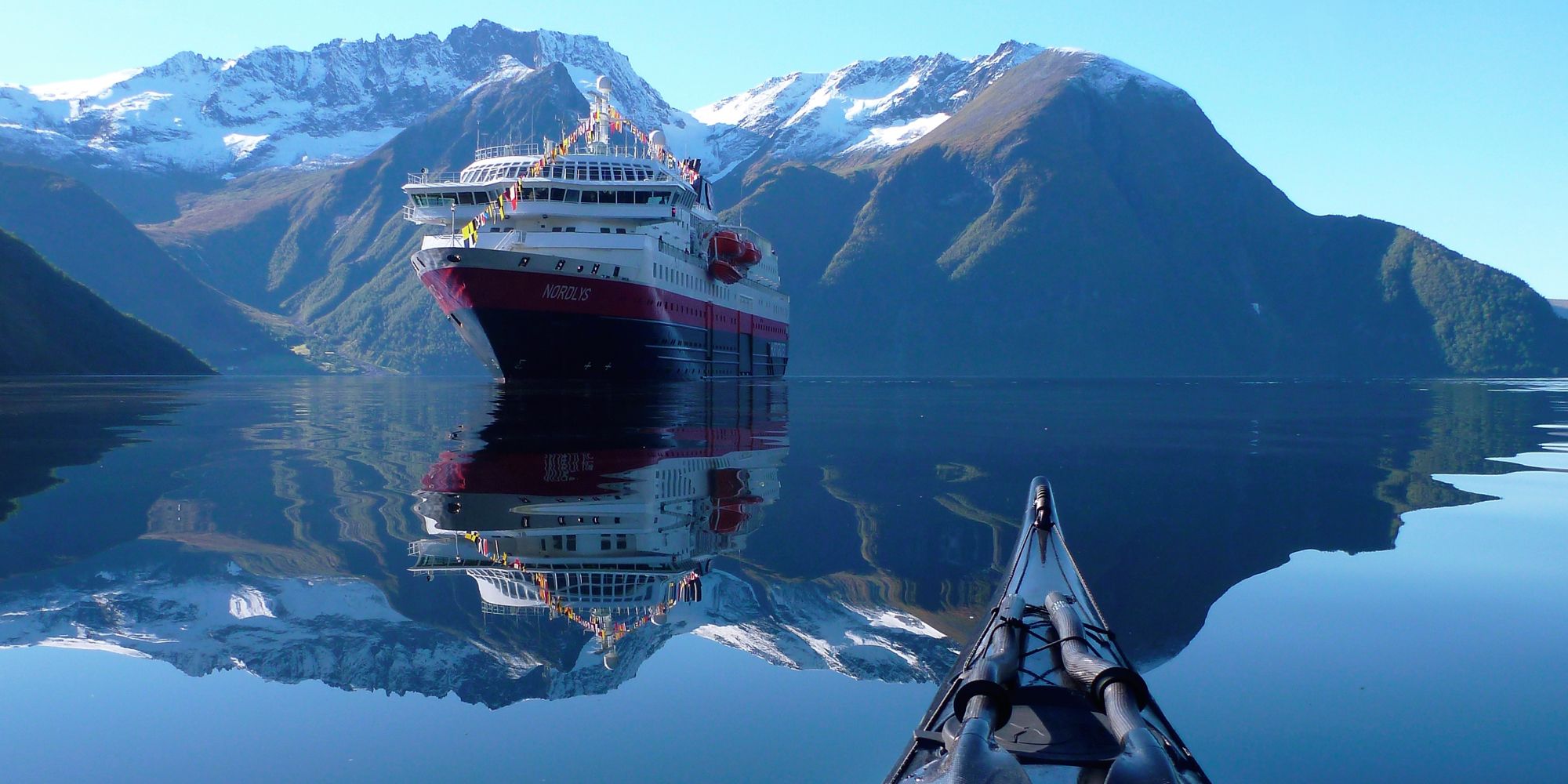 View of the Hurtigruten ship MS Nordlys from a kayak at Hjørundfjorden in Fjord Norway