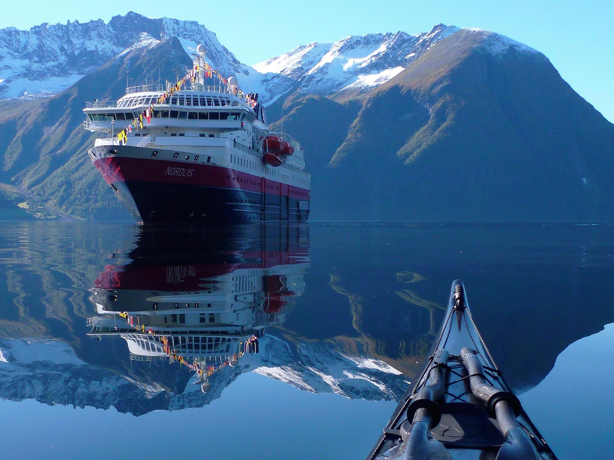 View of the Hurtigruten ship MS Nordlys from a kayak at Hjørundfjorden in Fjord Norway
