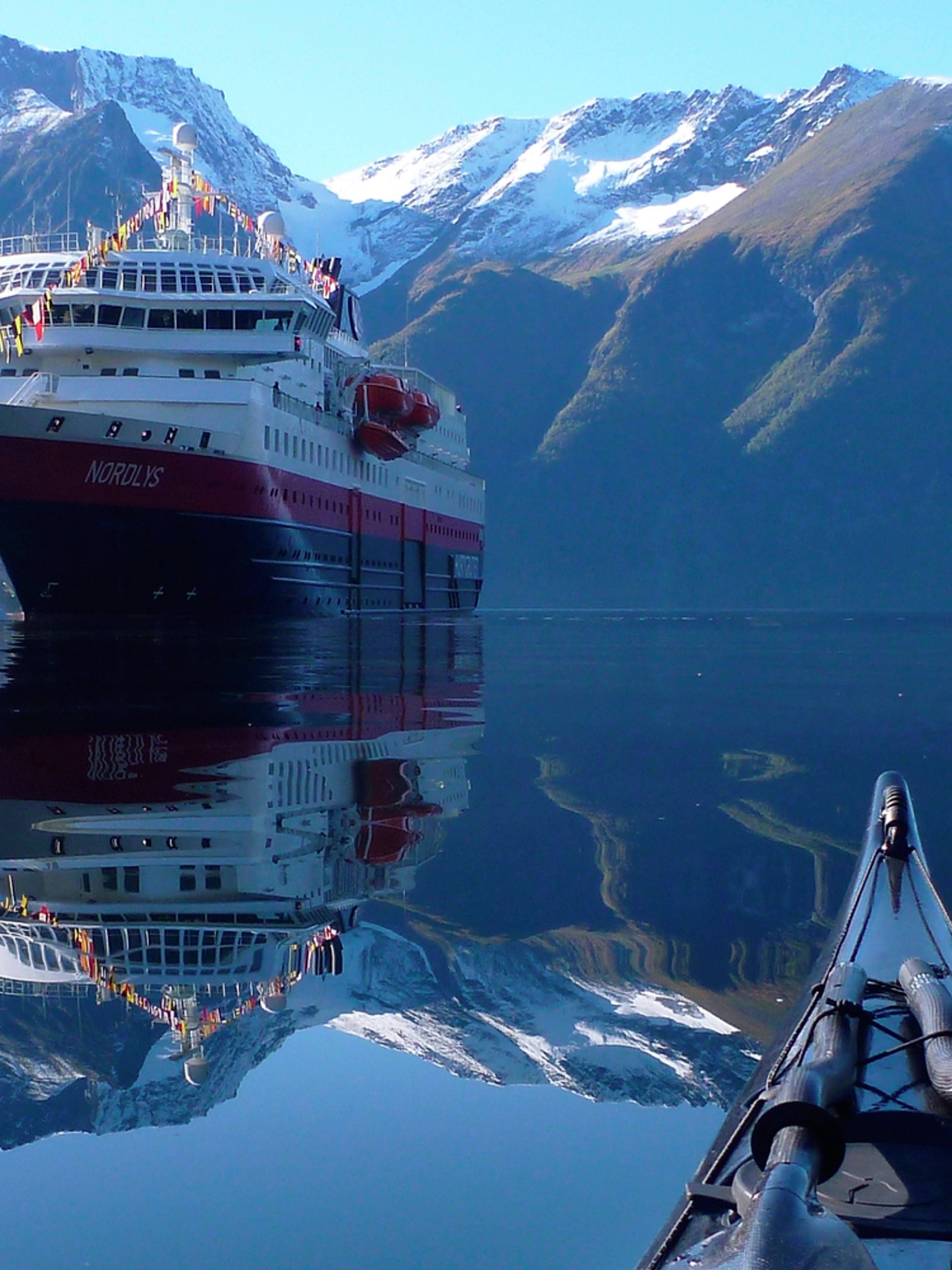 View of the Hurtigruten ship MS Nordlys from a kayak at Hjørundfjorden in Fjord Norway