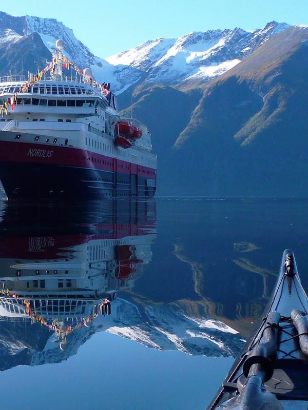 View of the Hurtigruten ship MS Nordlys from a kayak at Hjørundfjorden in Fjord Norway