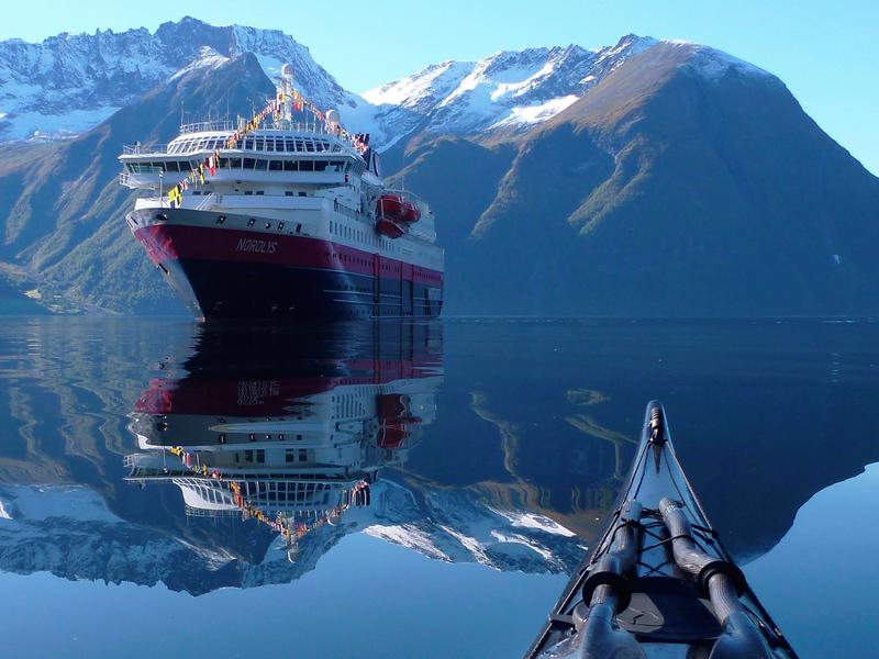 View of the Hurtigruten ship MS Nordlys from a kayak at Hjørundfjorden in Fjord Norway