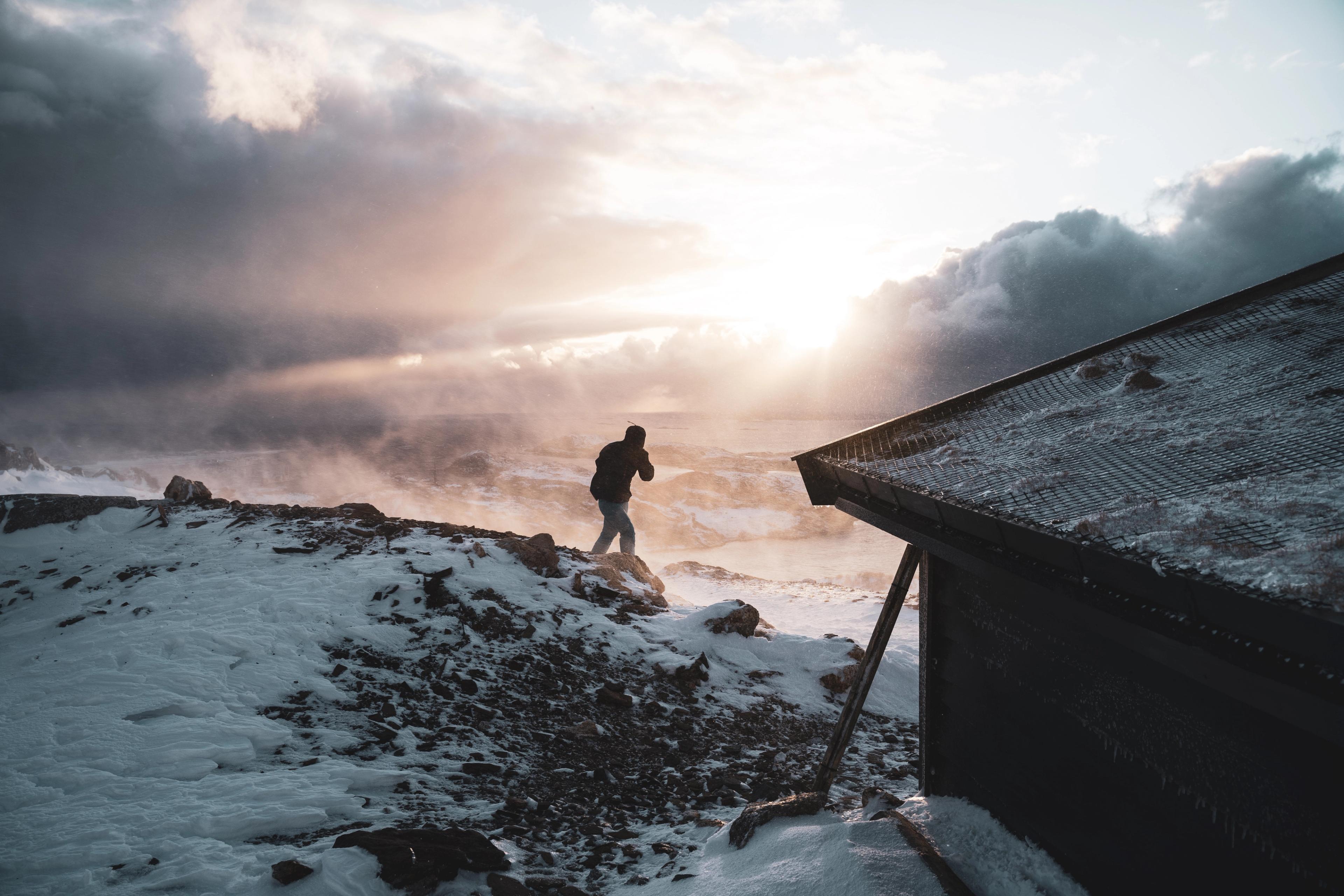 A person hiking on Keiservarden in Bodø in snow and wind.