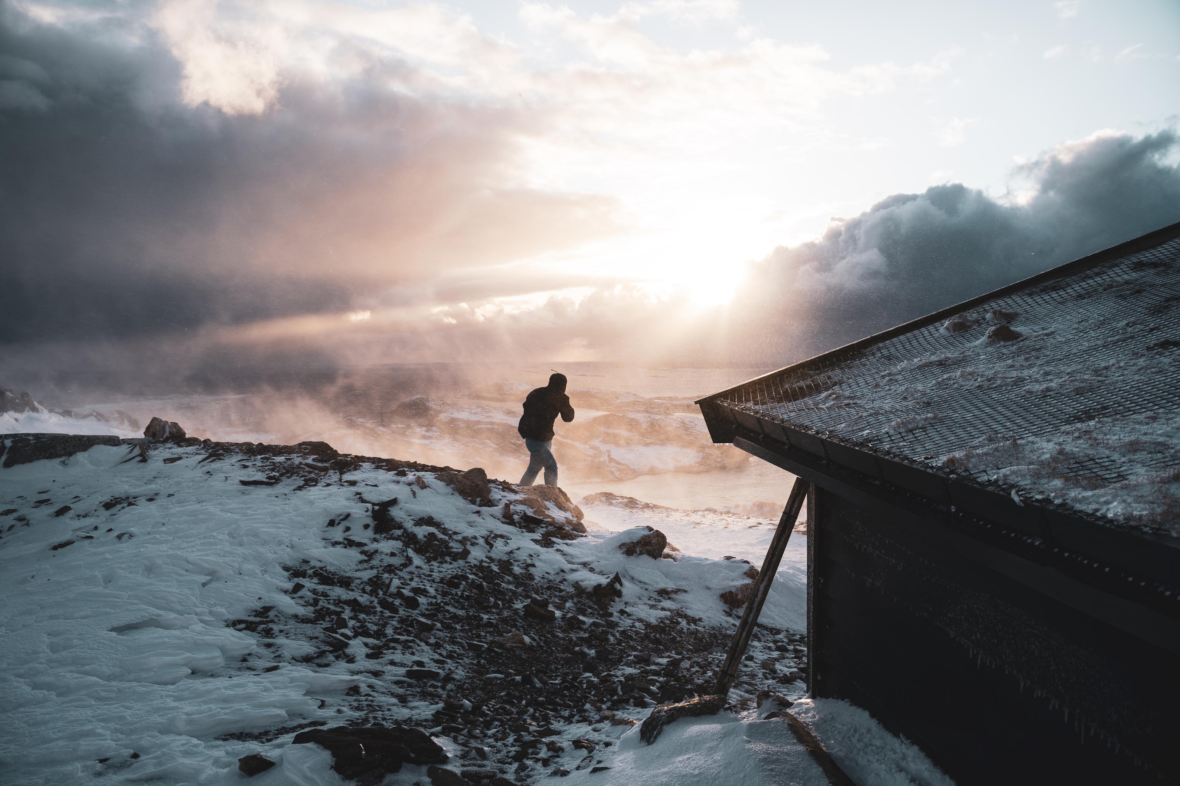 A person hiking on Keiservarden in Bodø in snow and wind.
