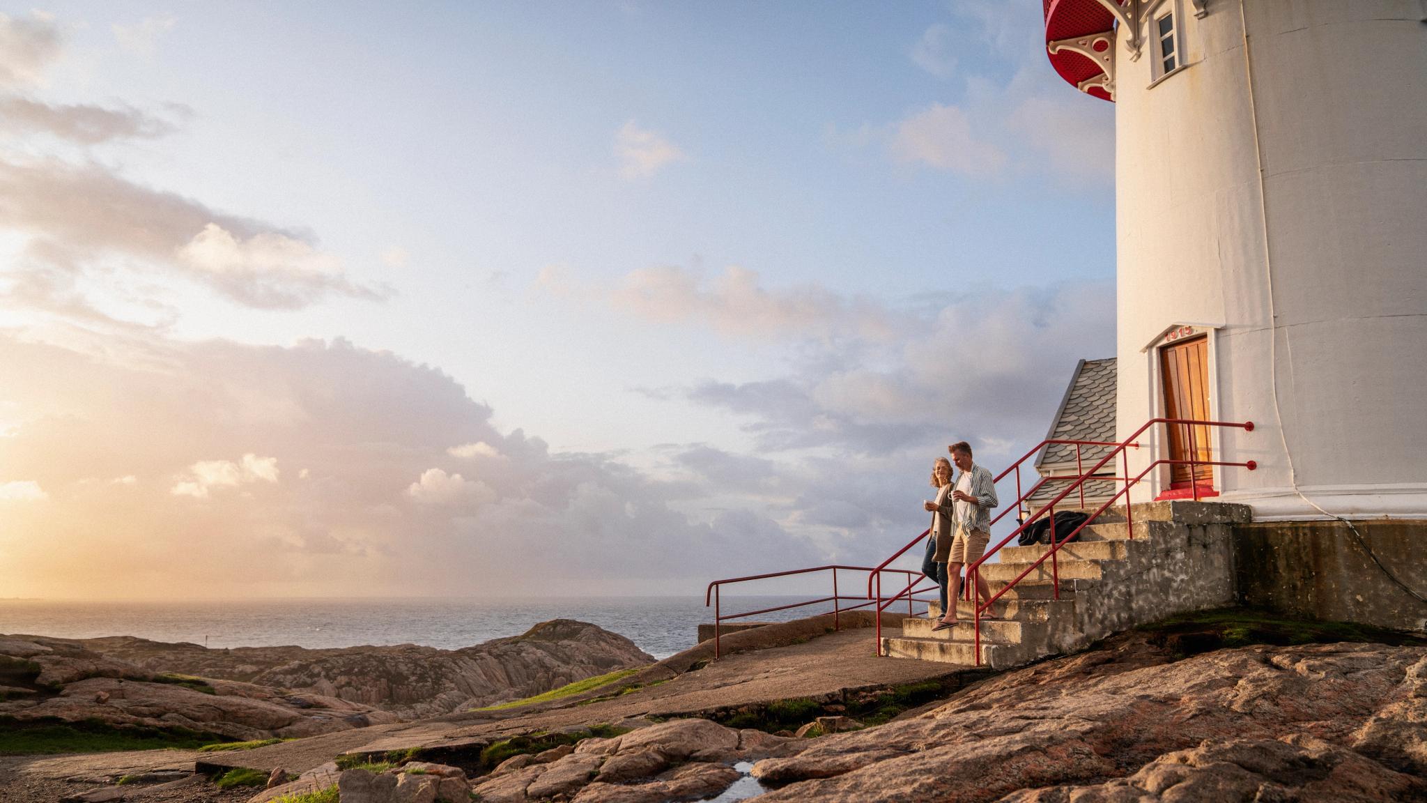 A couple walking beside a lighthouse in Southern Norway.
